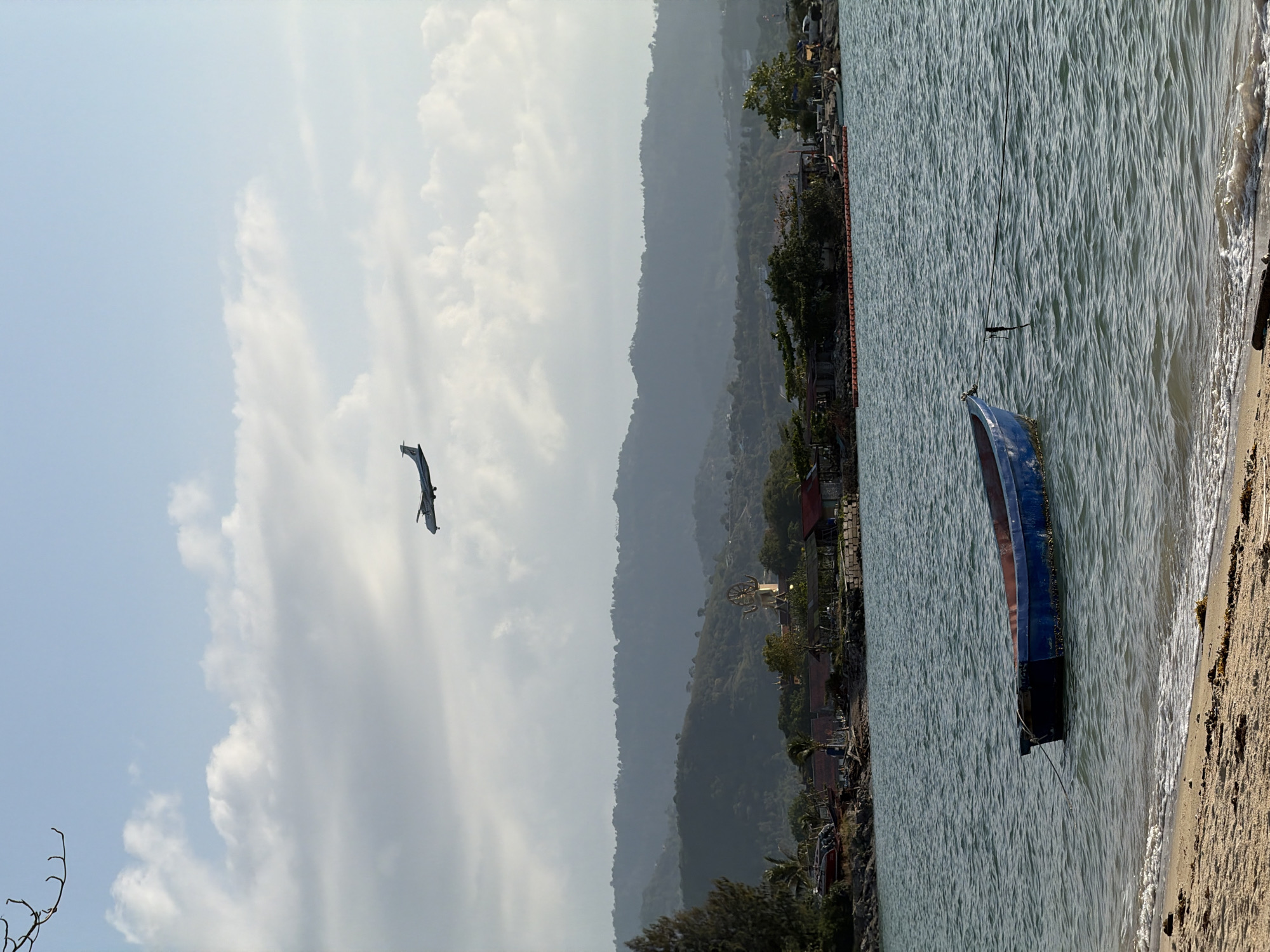 Plane descends over Ko Samui as beach life carries on below