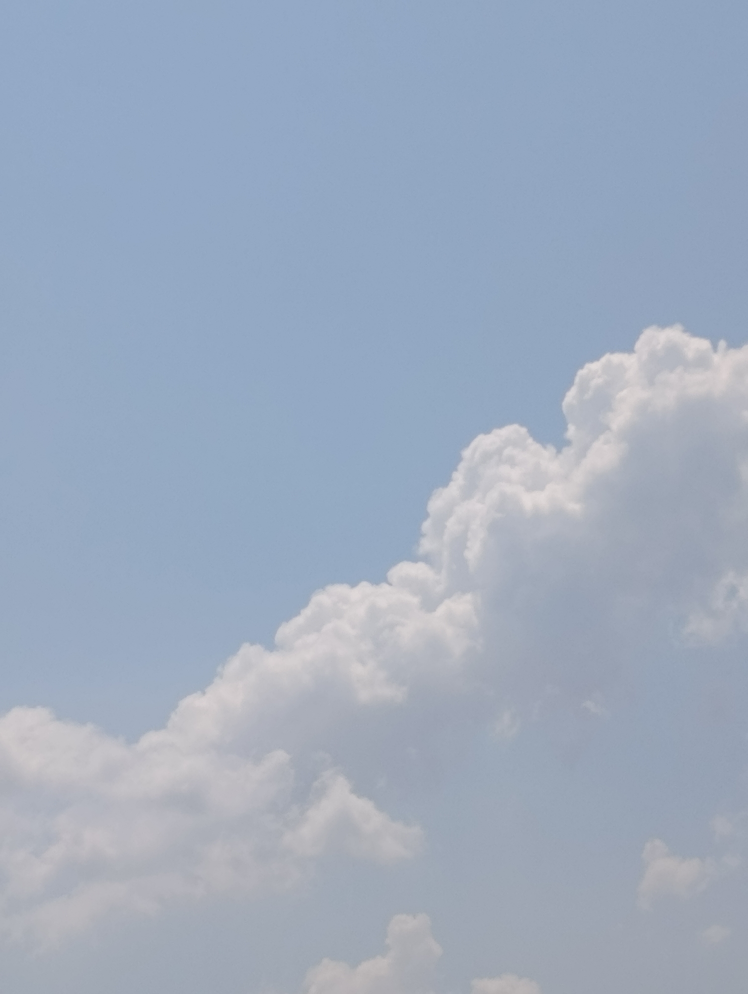 Cumulus cloud drifts across a pale blue sky over Varna