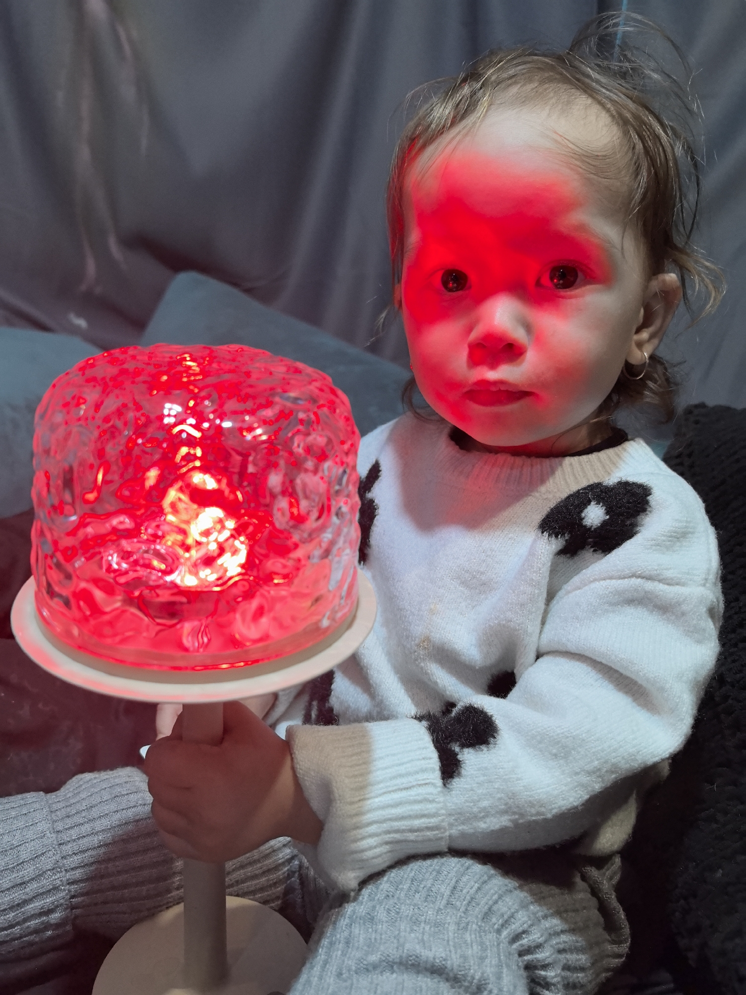 Child plays with colorful lamps in Noviy, Russia