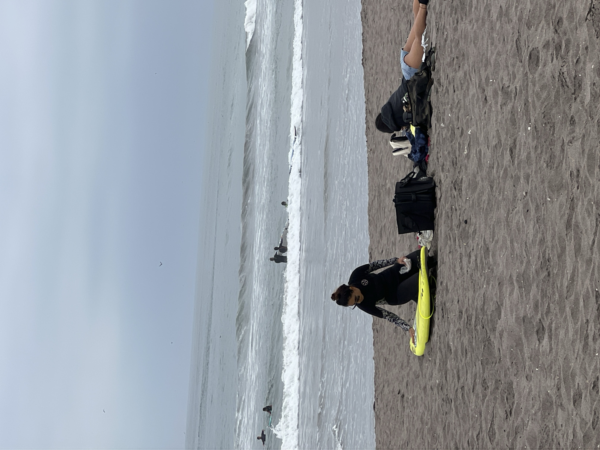Overcast afternoon brings surfers and families to Arica beach