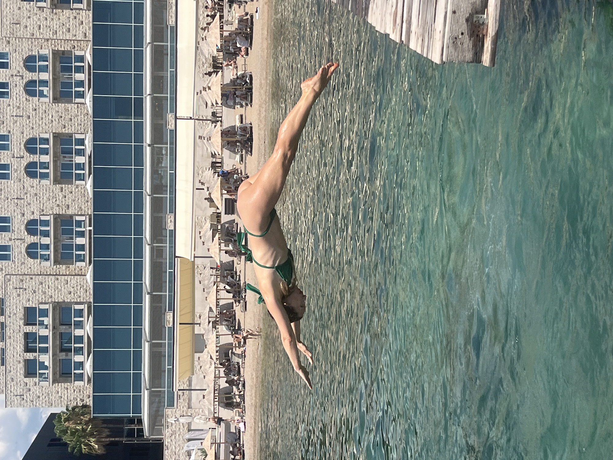 Diving into turquoise Adriatic water off Budva's concrete ledges