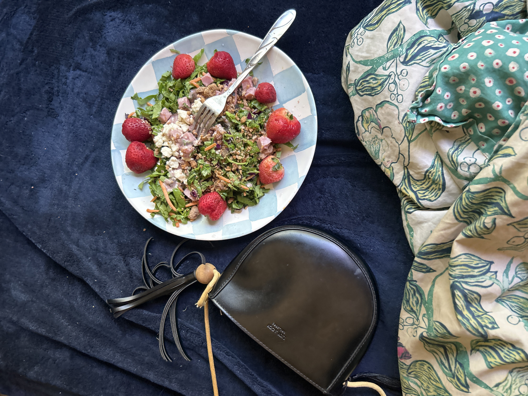Purse and salad on a blanket, classic LA lunch moment.