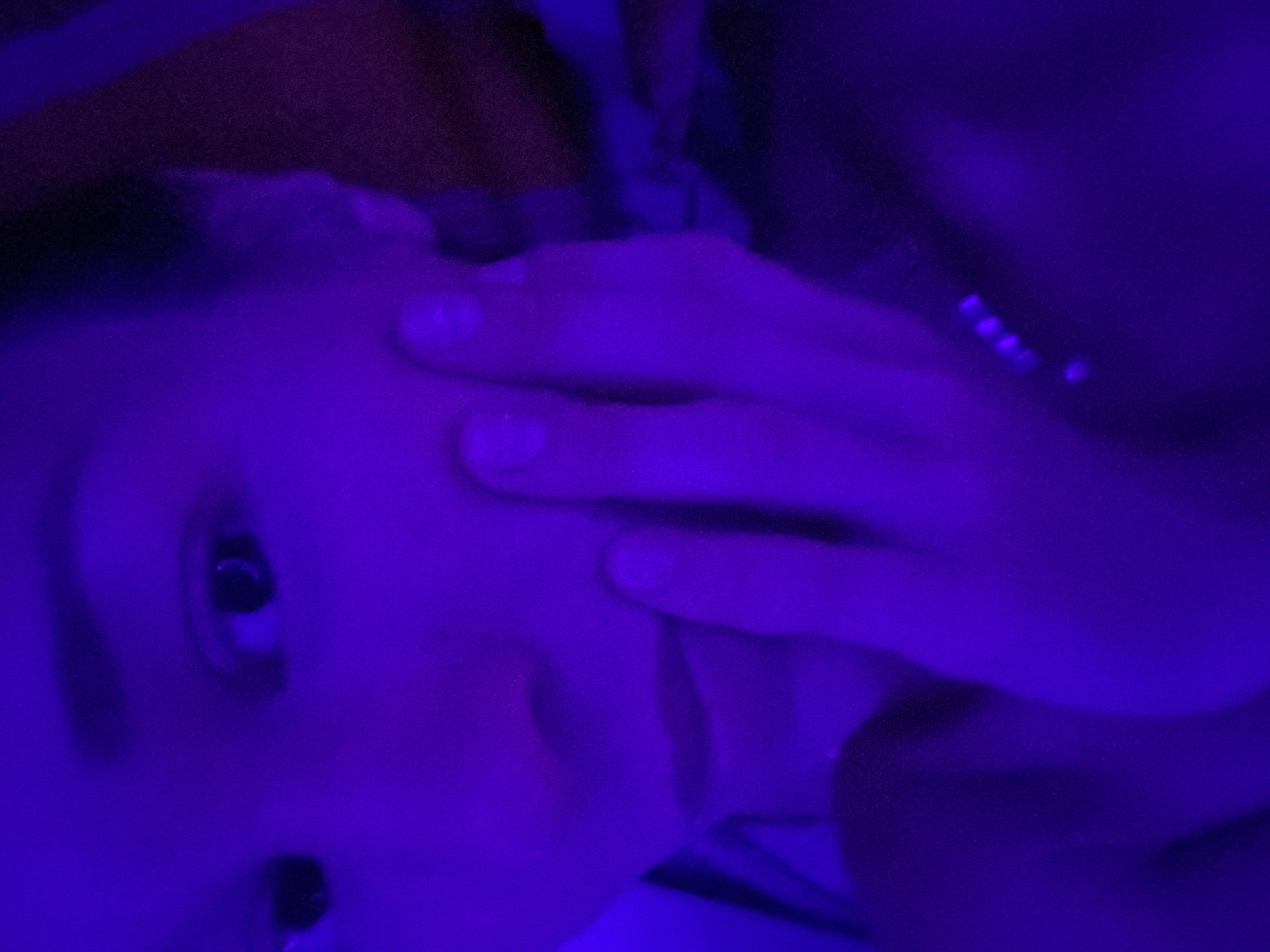 Person and ornate fabrics photographed under blue lighting in Thailand