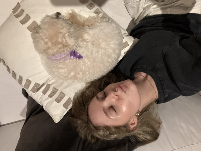 Girl and small dog rest together indoors in Coral Gables