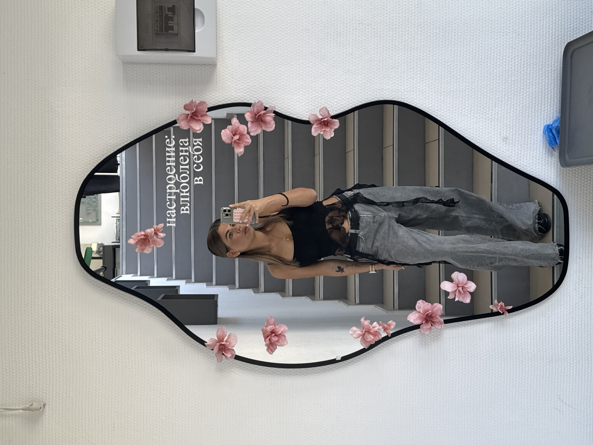 Woman takes mirror selfie in decorated stairwell in Chaikovsky