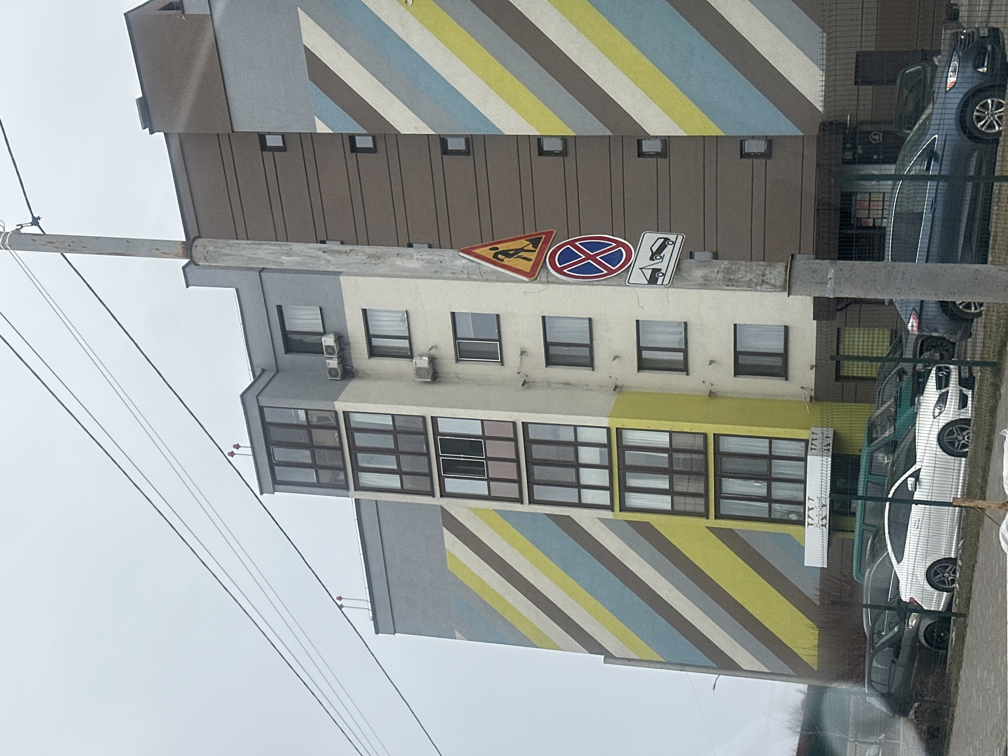 Woman cycles past apartment building in early morning Kyiv