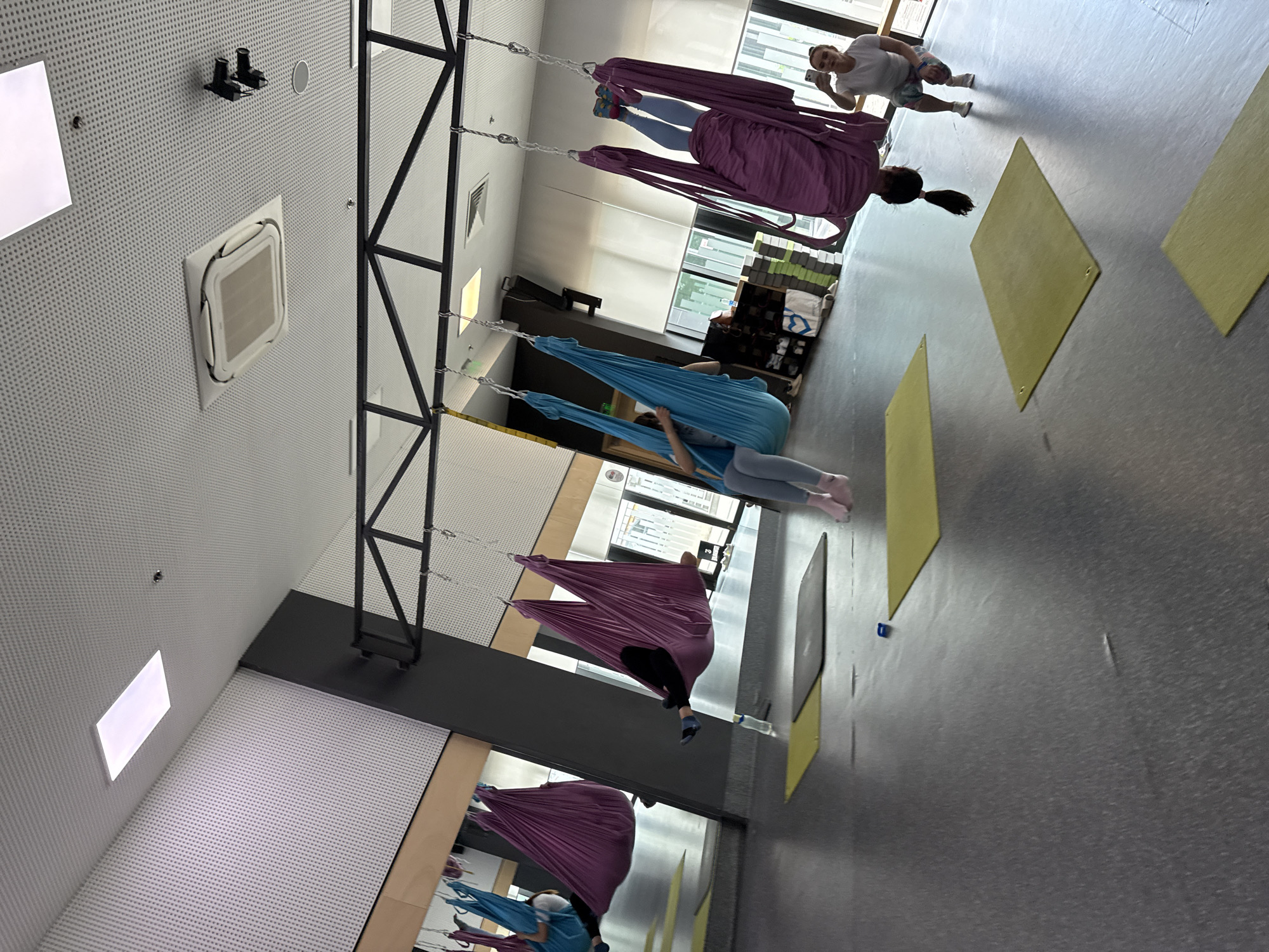 Aerial yoga session in a colorful hammock studio