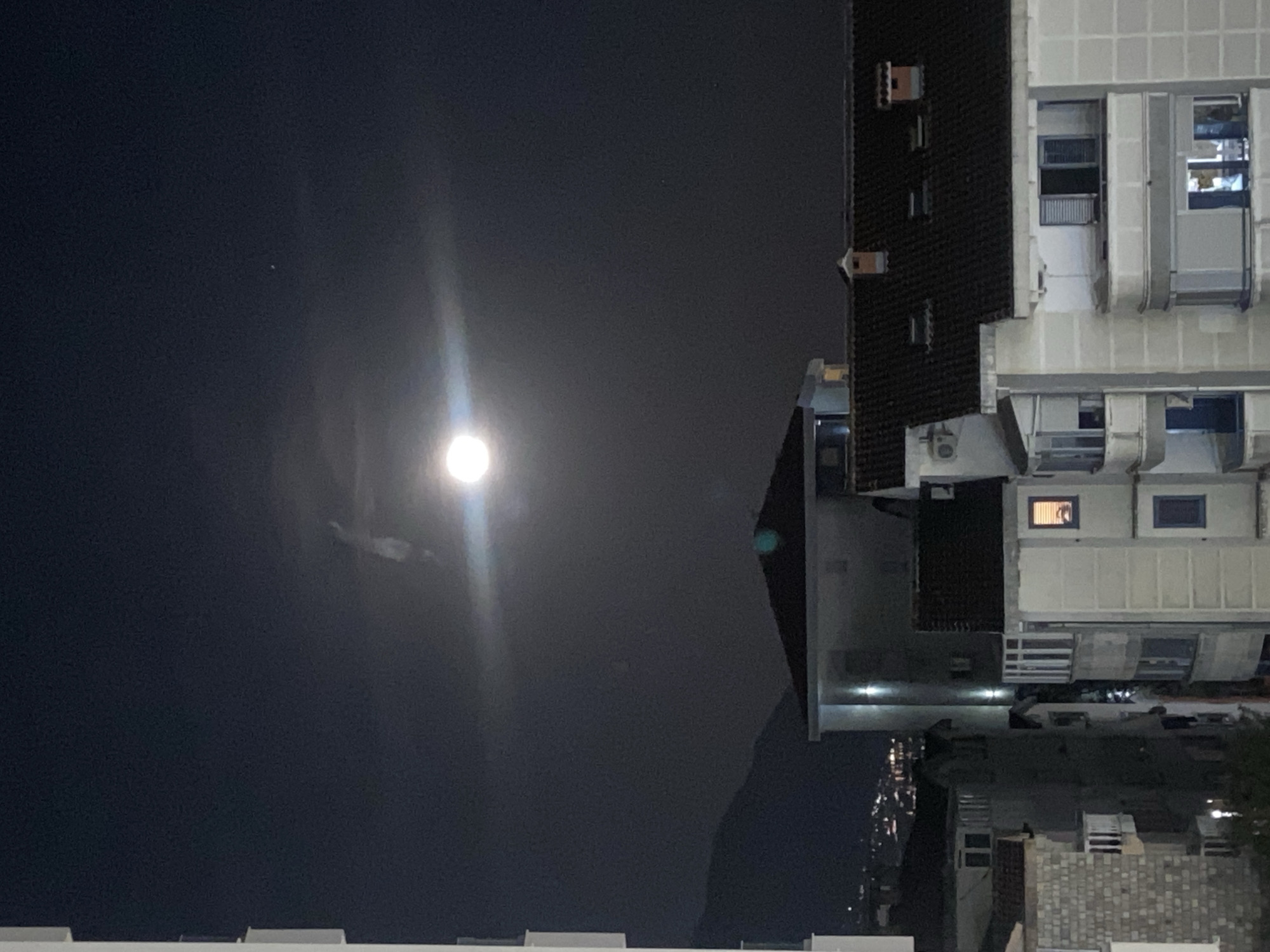 Bright moon illuminates nighttime urban scene in Budva, Montenegro