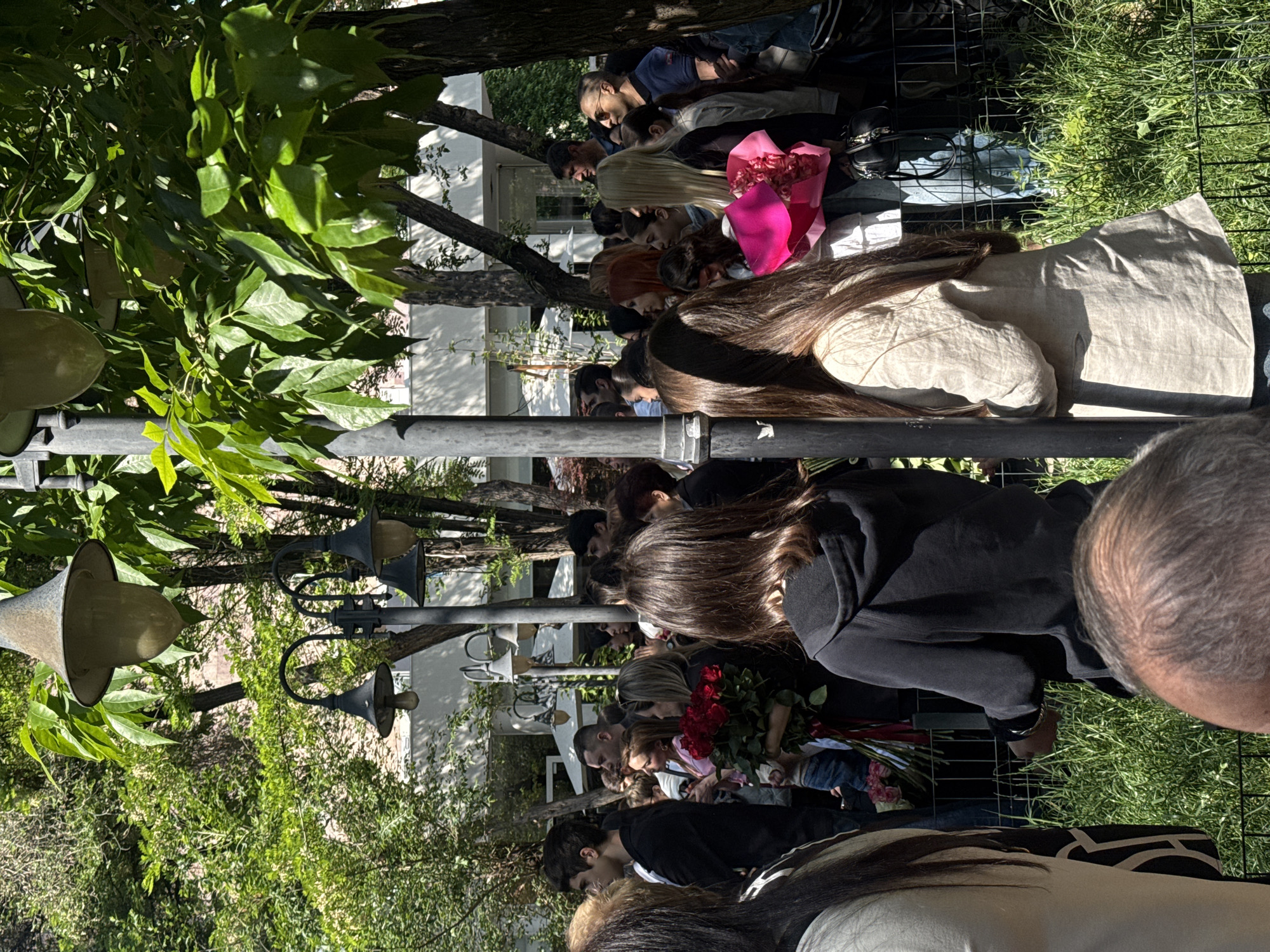 Flower-bearing crowds gather at decorated building in Yerevan