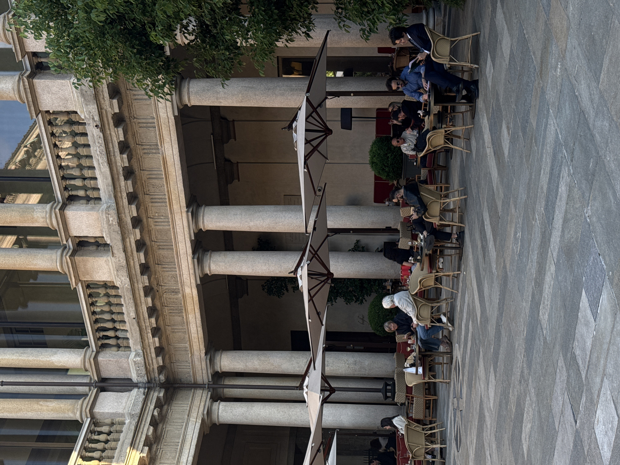 Afternoon dining scene captured at Milan's classical courtyard venue