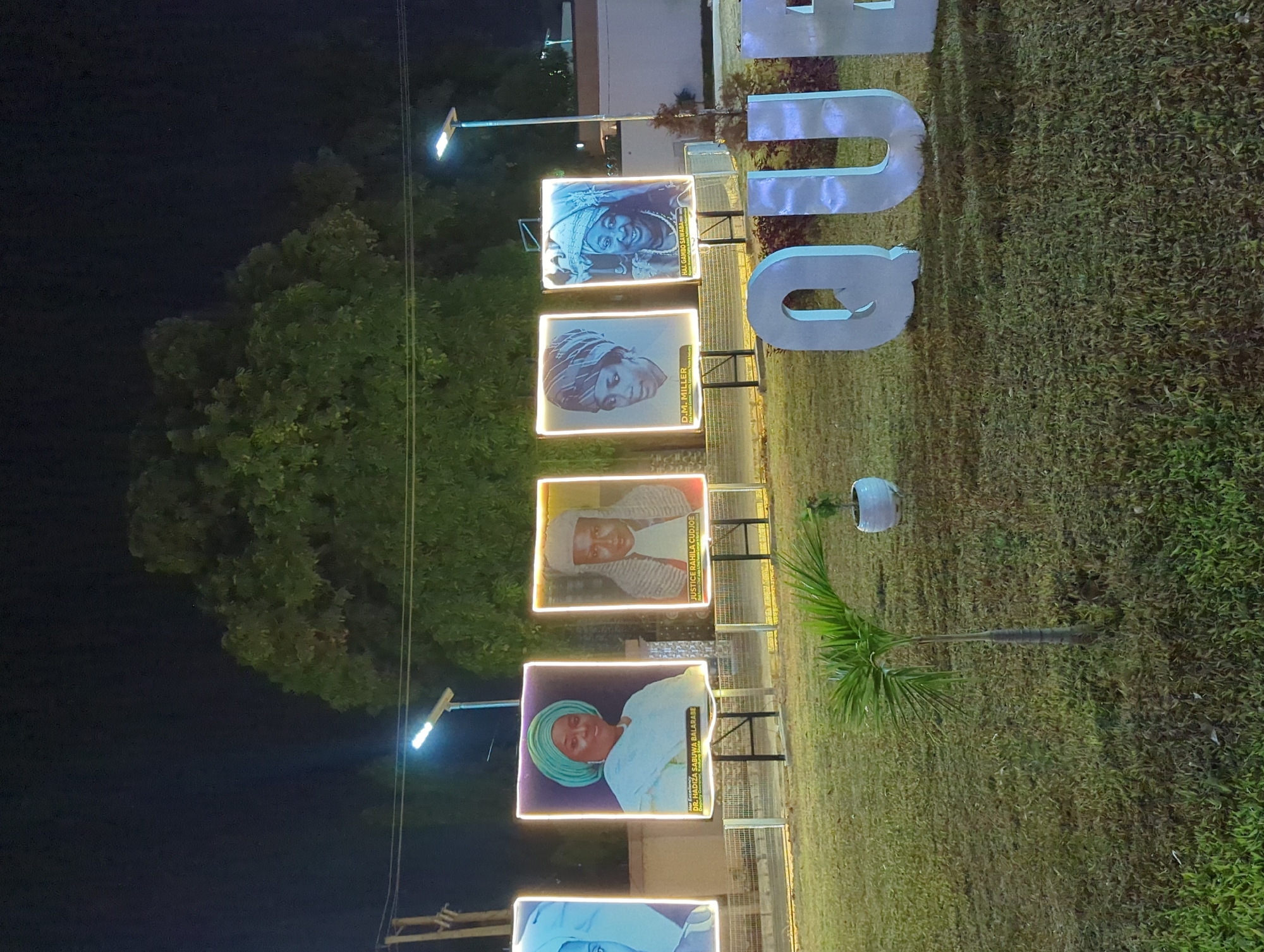 Illuminated memorial portraits displayed at night in Nigerian park