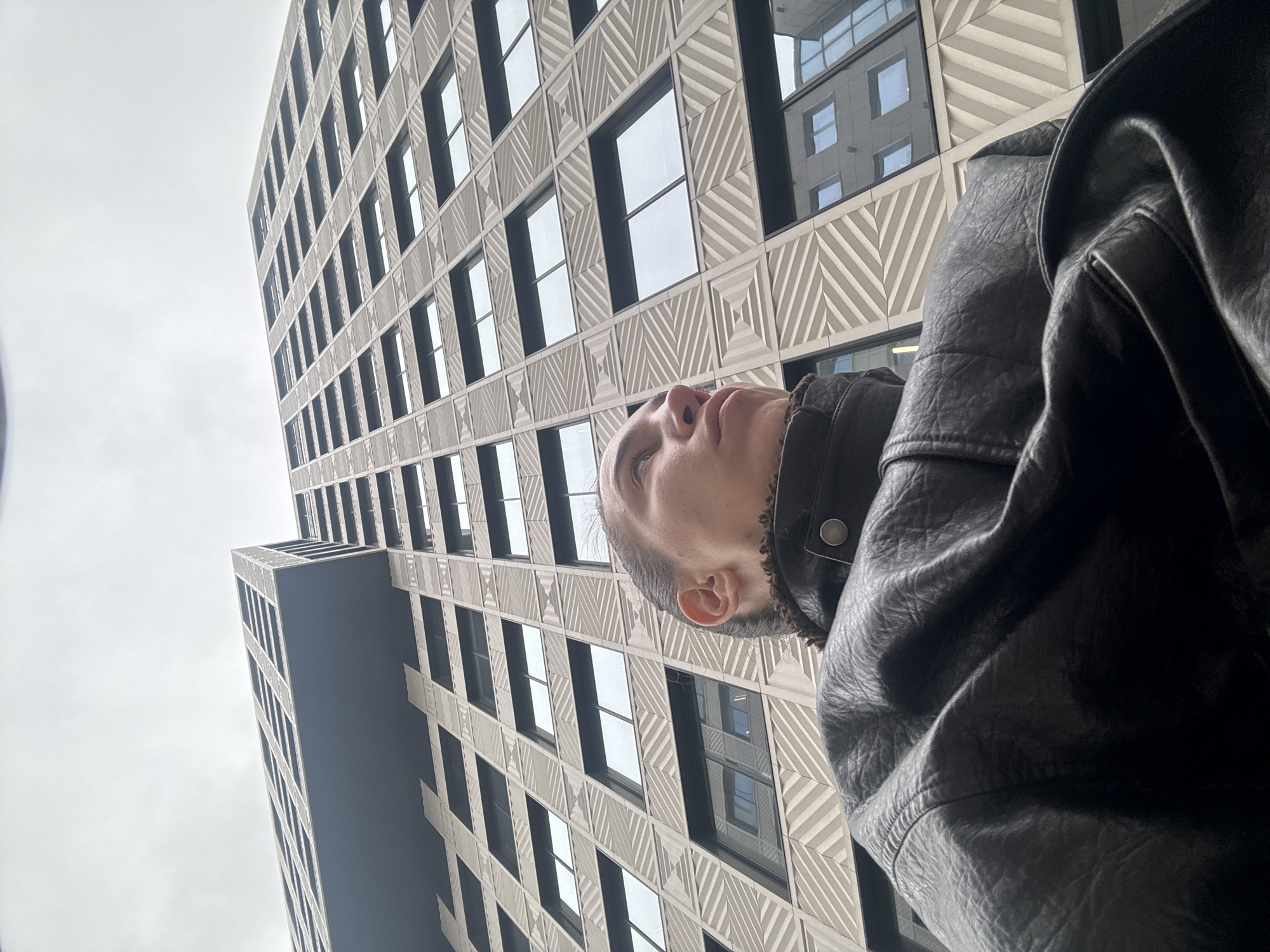 Person gazes up at modern building in Moscow