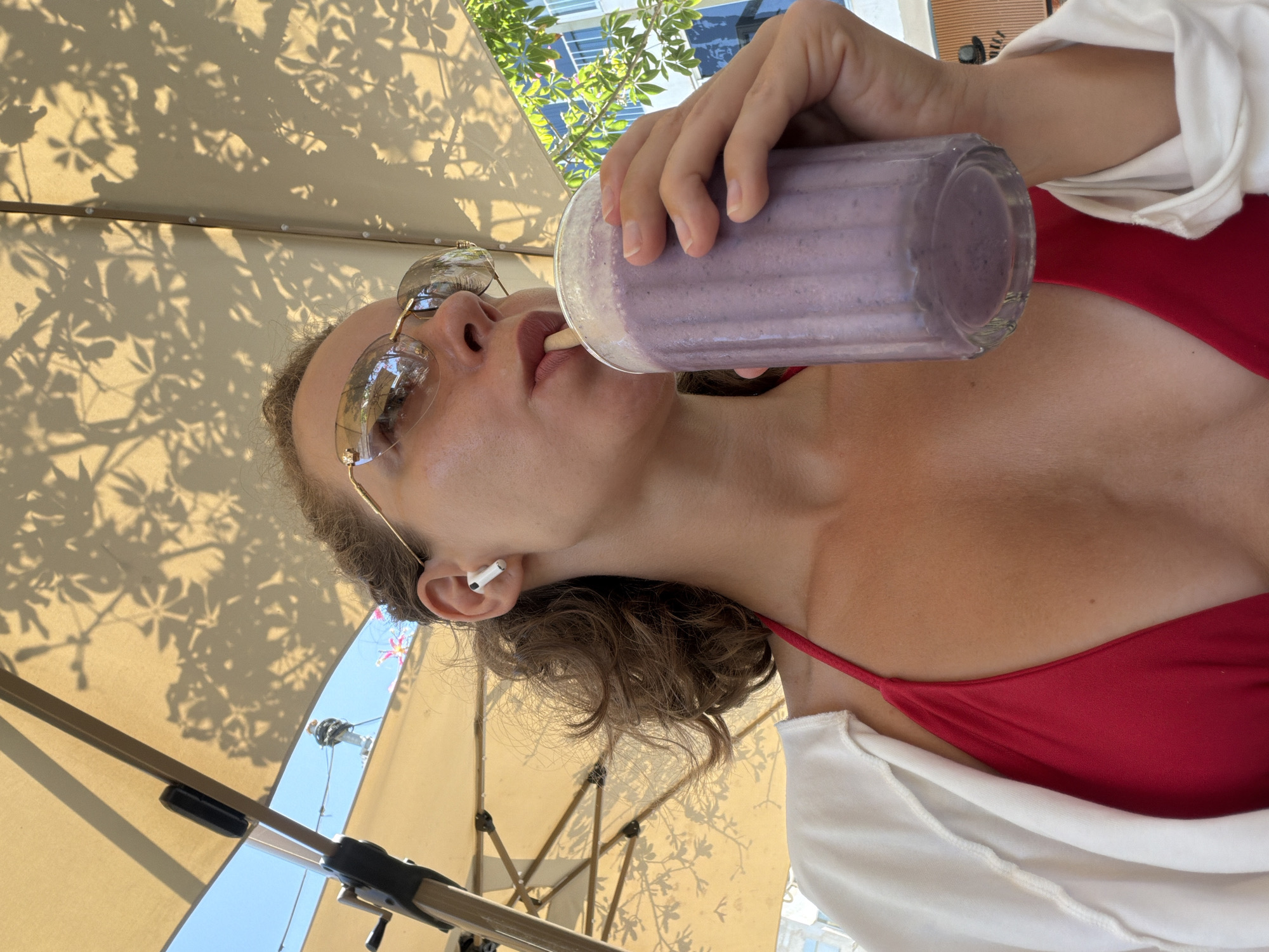 Purple smoothie and earbuds on a Tel Aviv summer morning