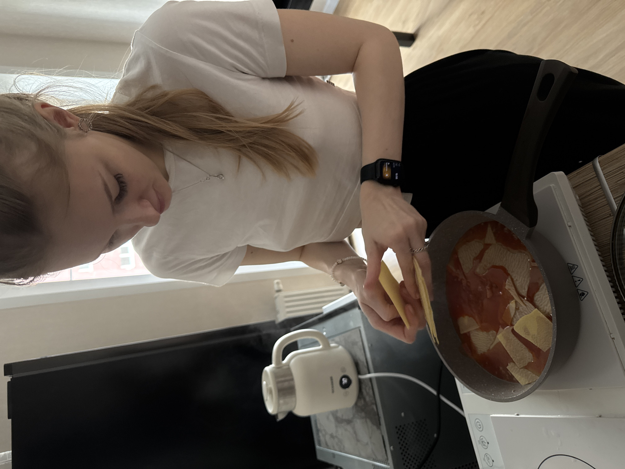 Woman prepares lasagna in Perm kitchen