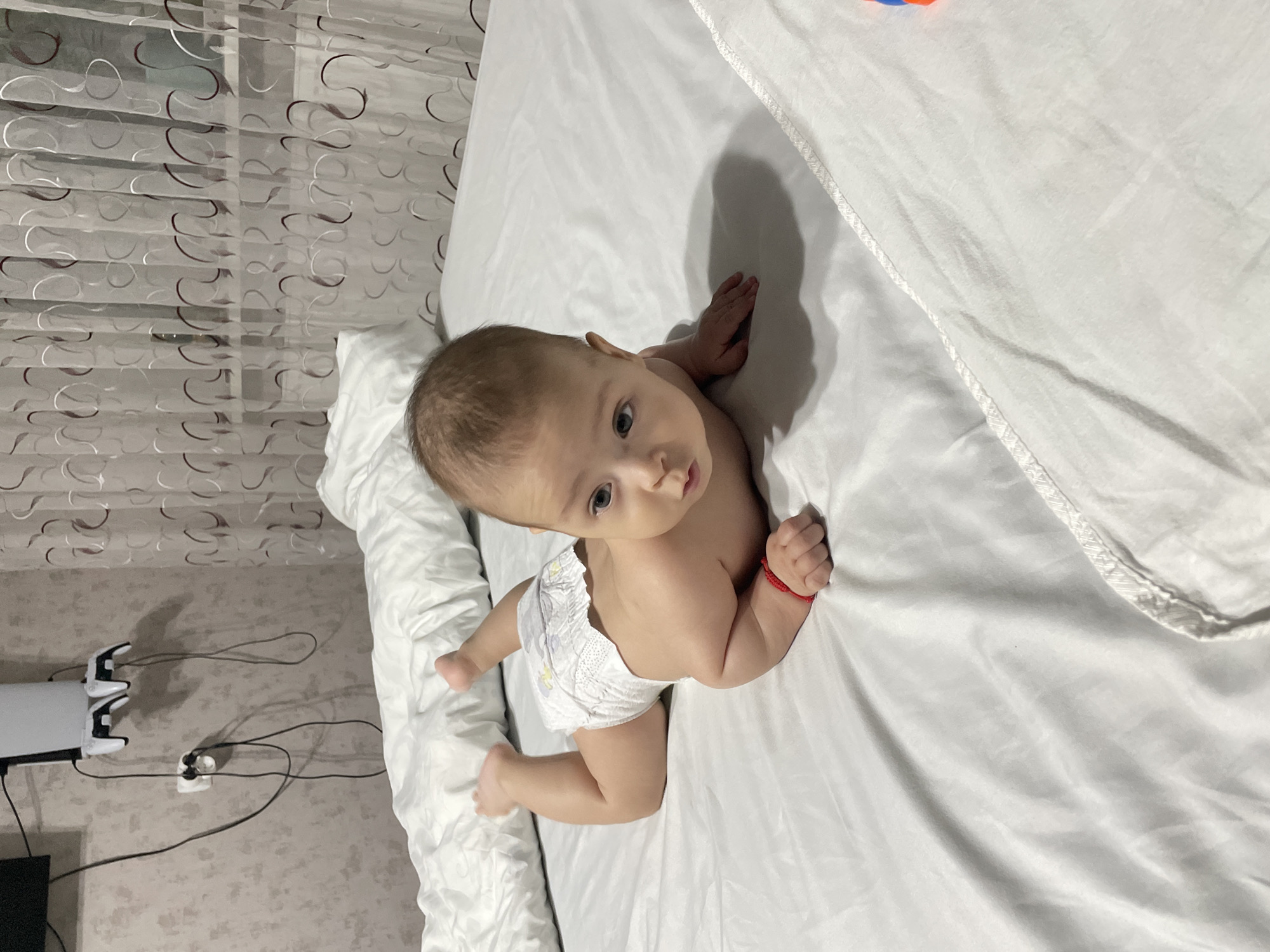 Baby on white sheets, curious and still, Fălești
