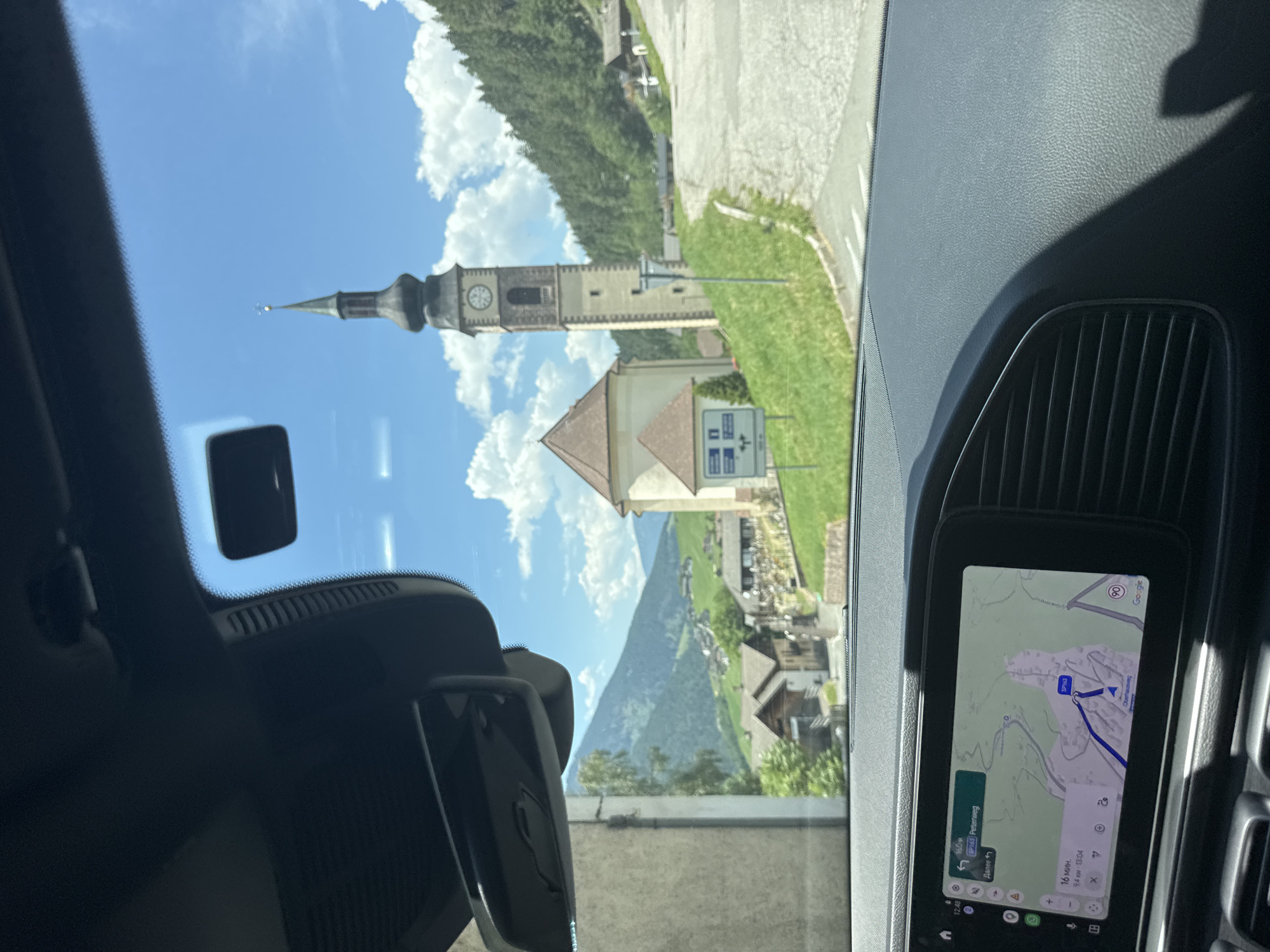 Alpine village and church steeple seen from a passing vehicle