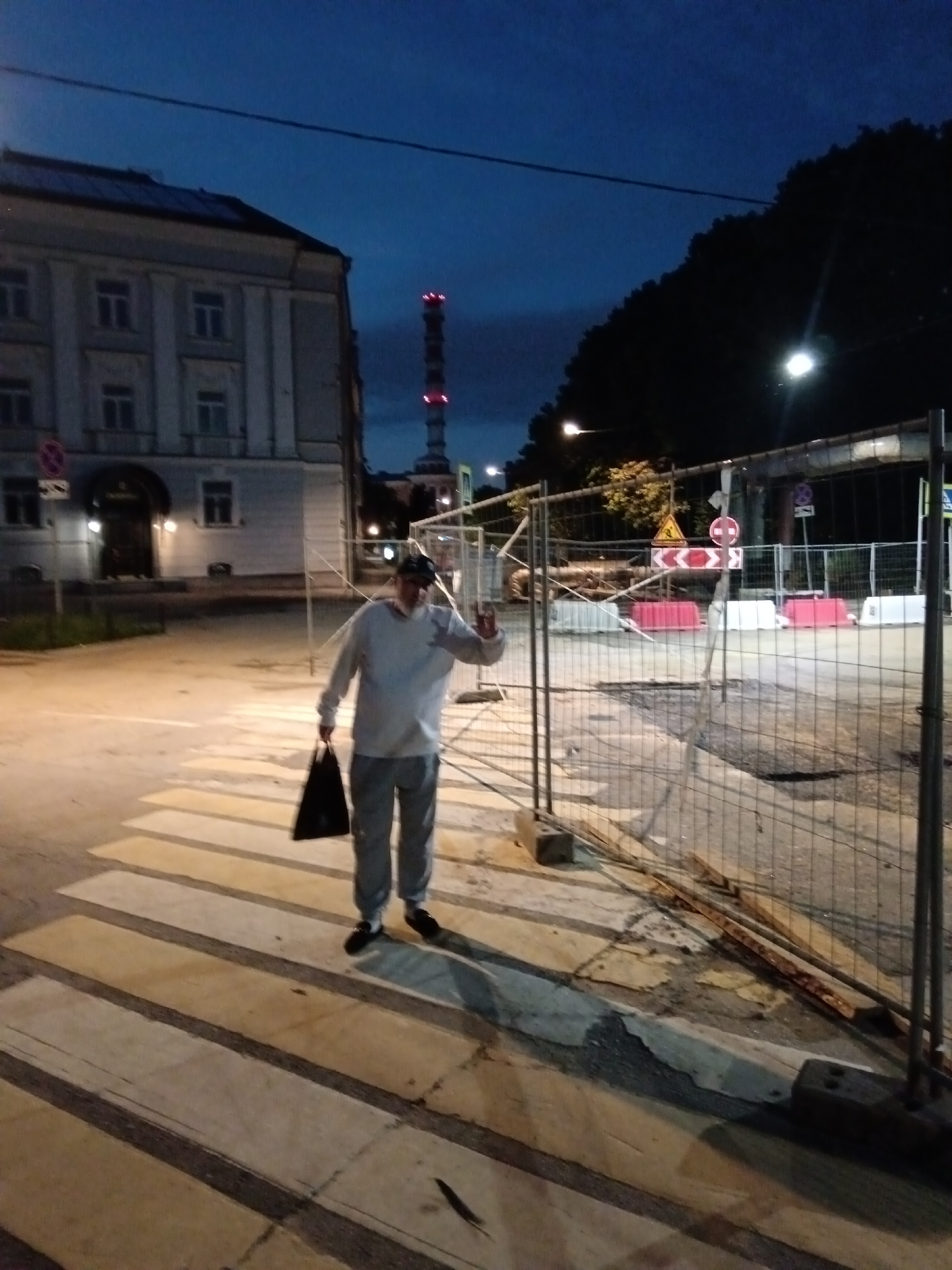 Nighttime street construction on a city boulevard near a domed building