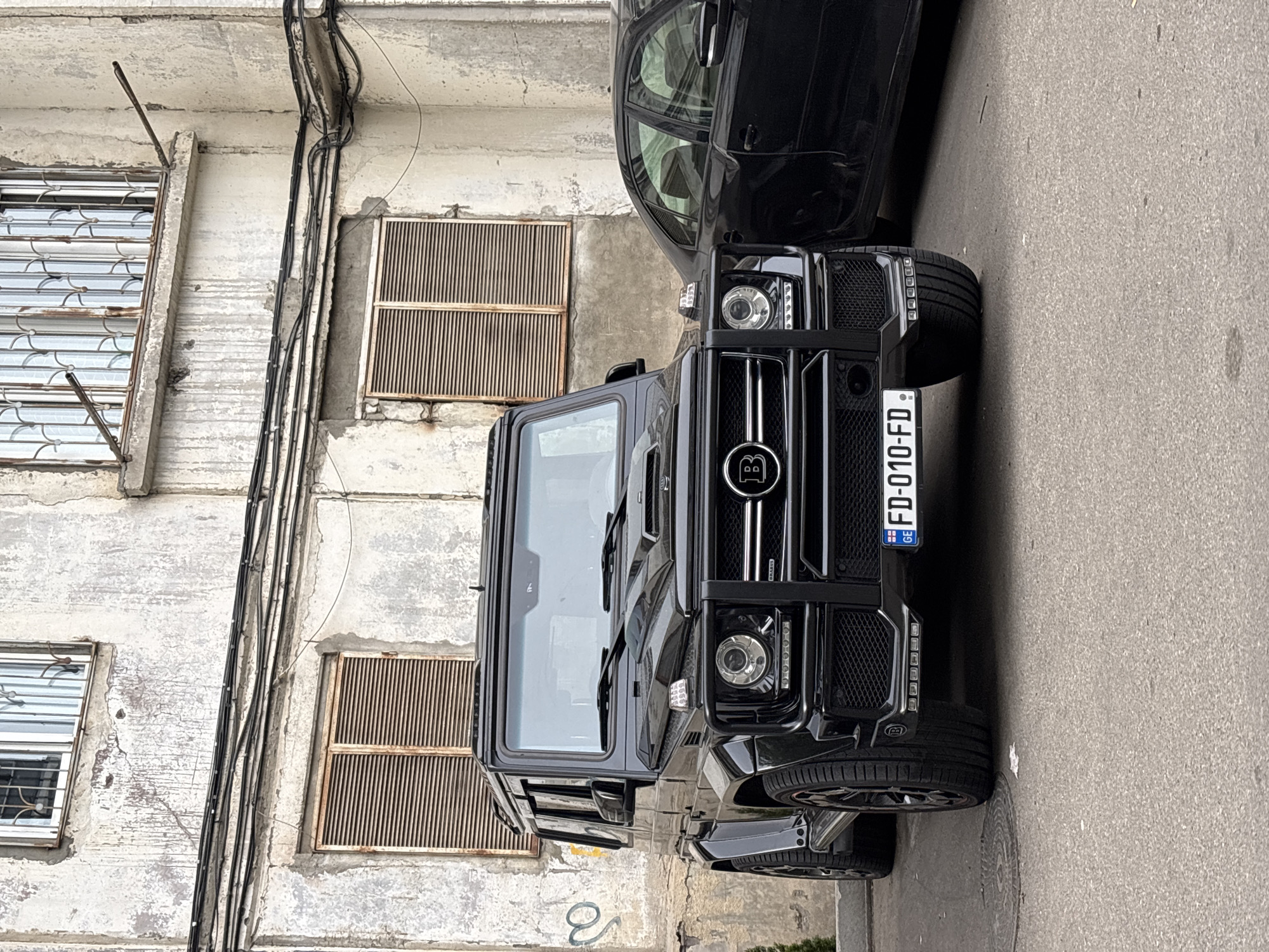 Street scenes documented in Tbilisi featuring luxury SUV, murals