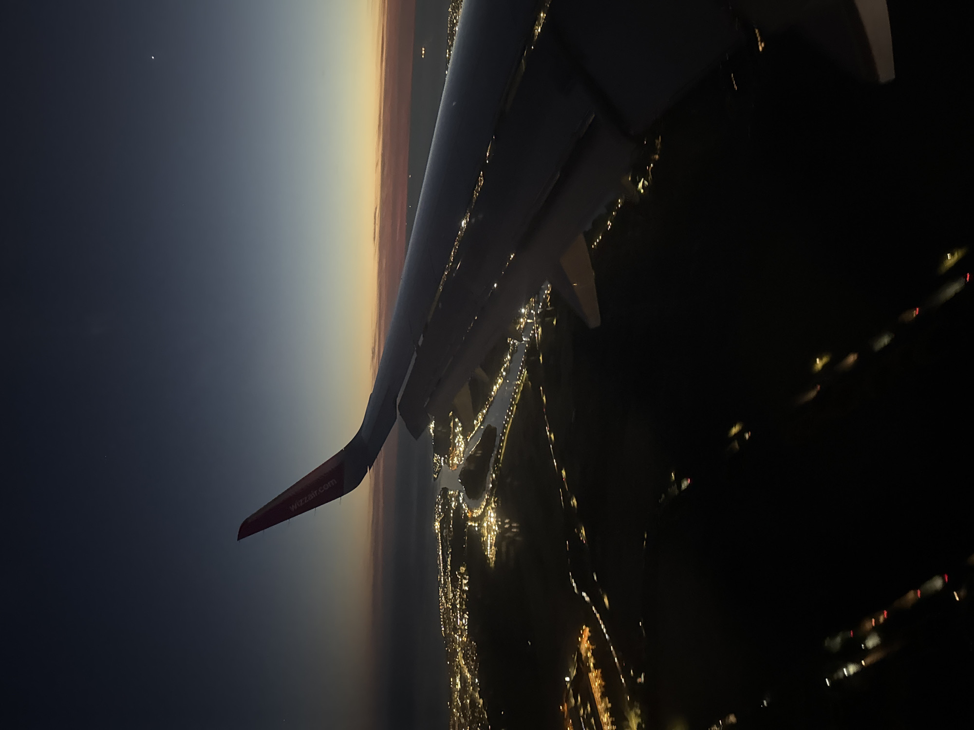 Wizz Air passenger documents evening flight over illuminated Rome