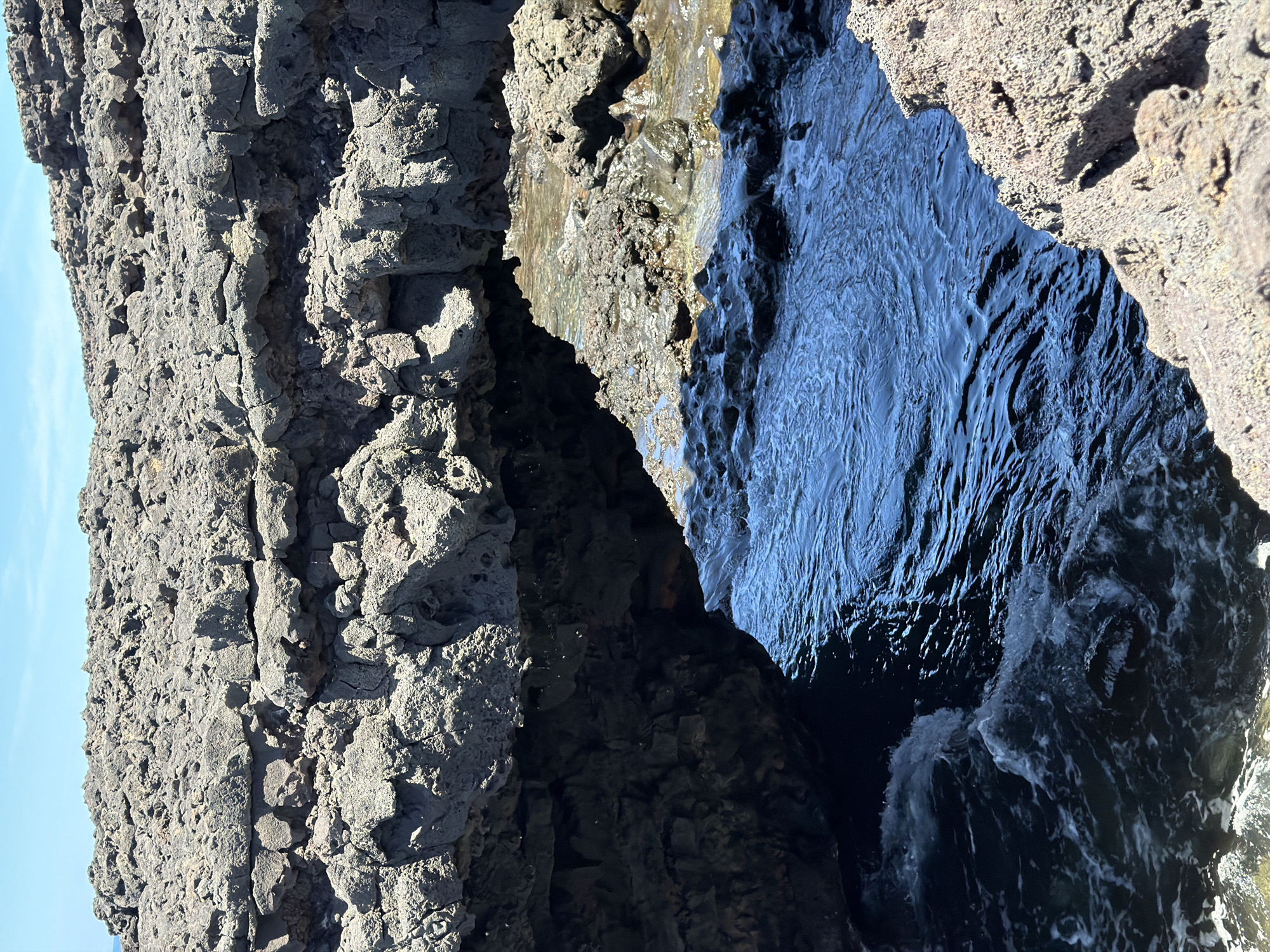 Ocean waves crash against volcanic rocks in Tinajo, Spain