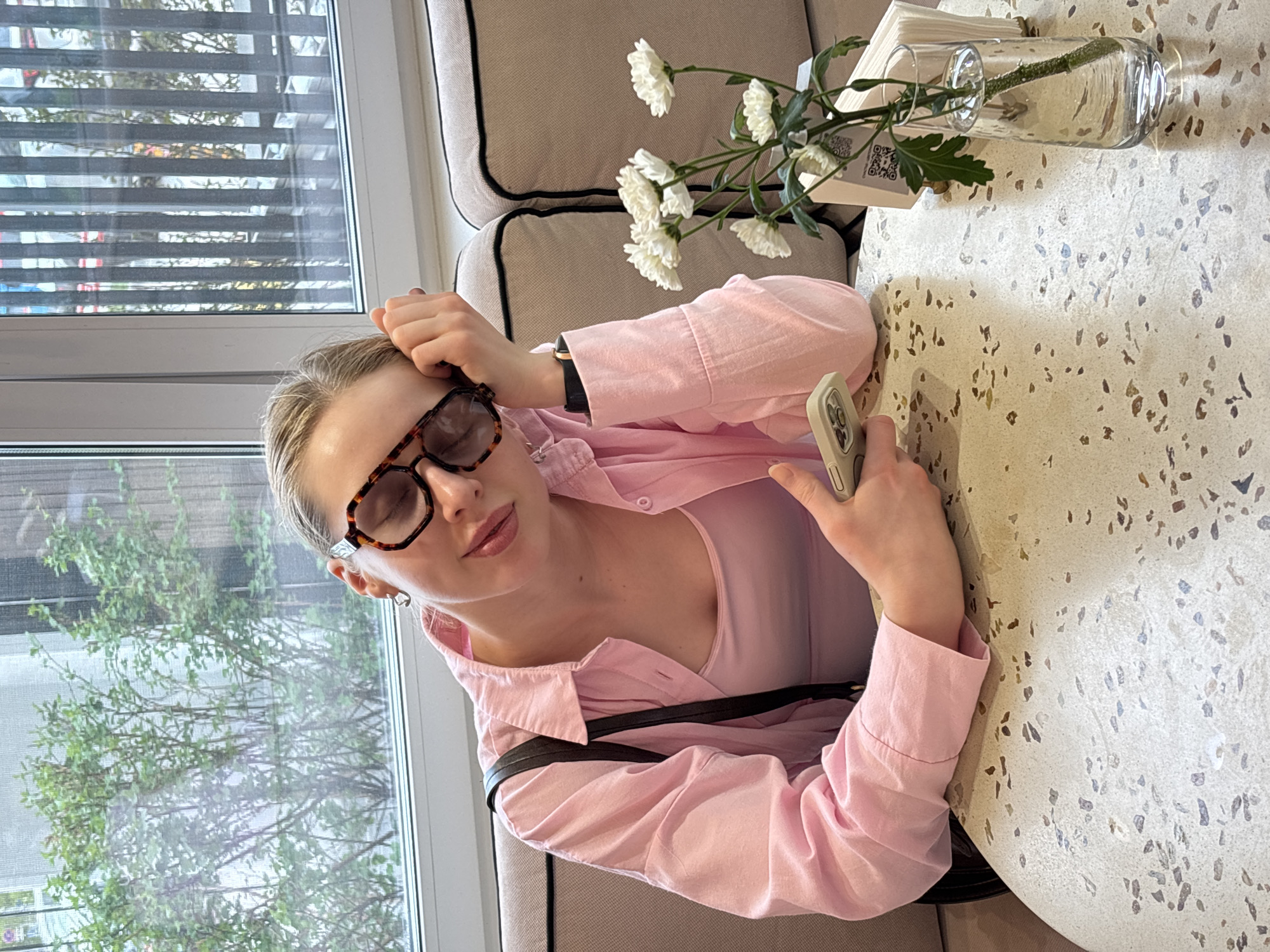Woman uses phone at pastry cafe in Perm