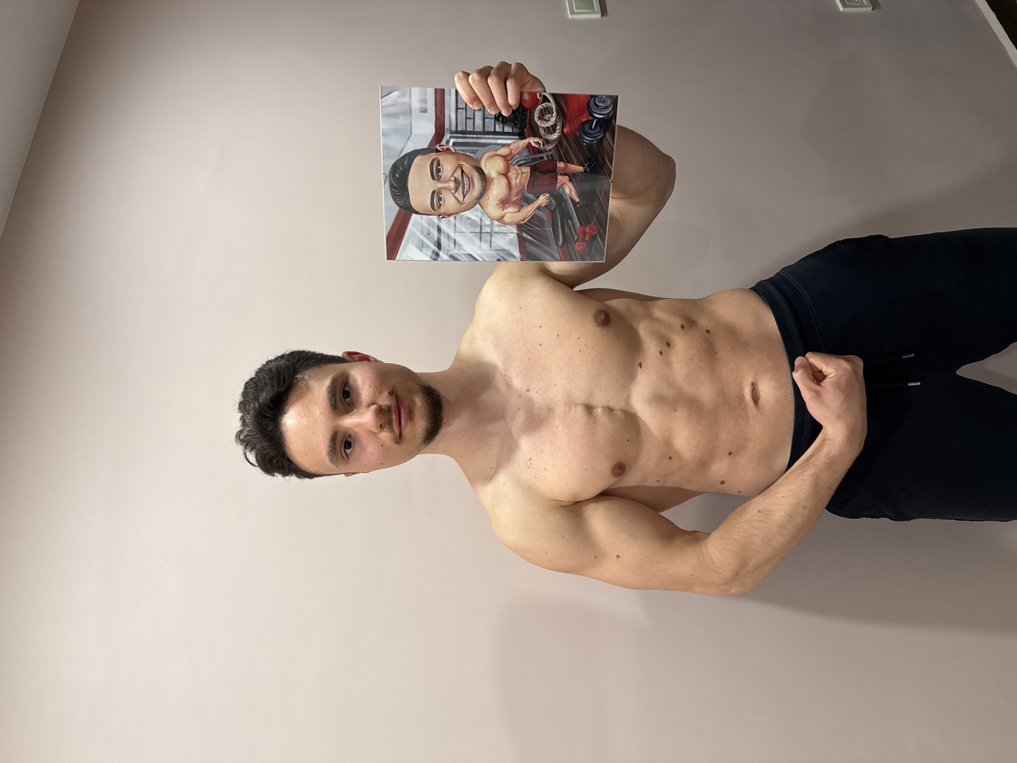 Athletic man photographed indoors against plain wall