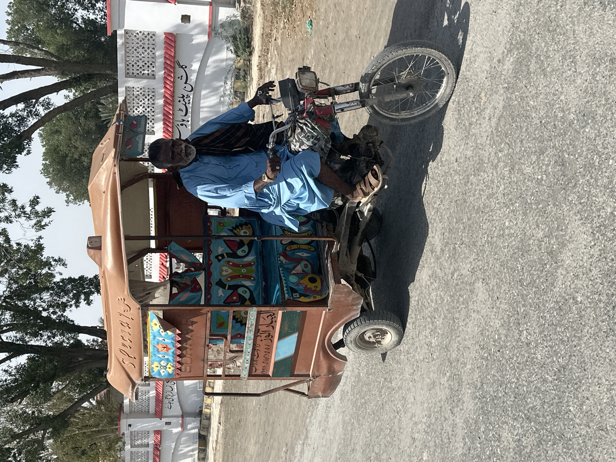 Morning traffic includes rickshaws, motorcycles, cargo trikes on paved roads