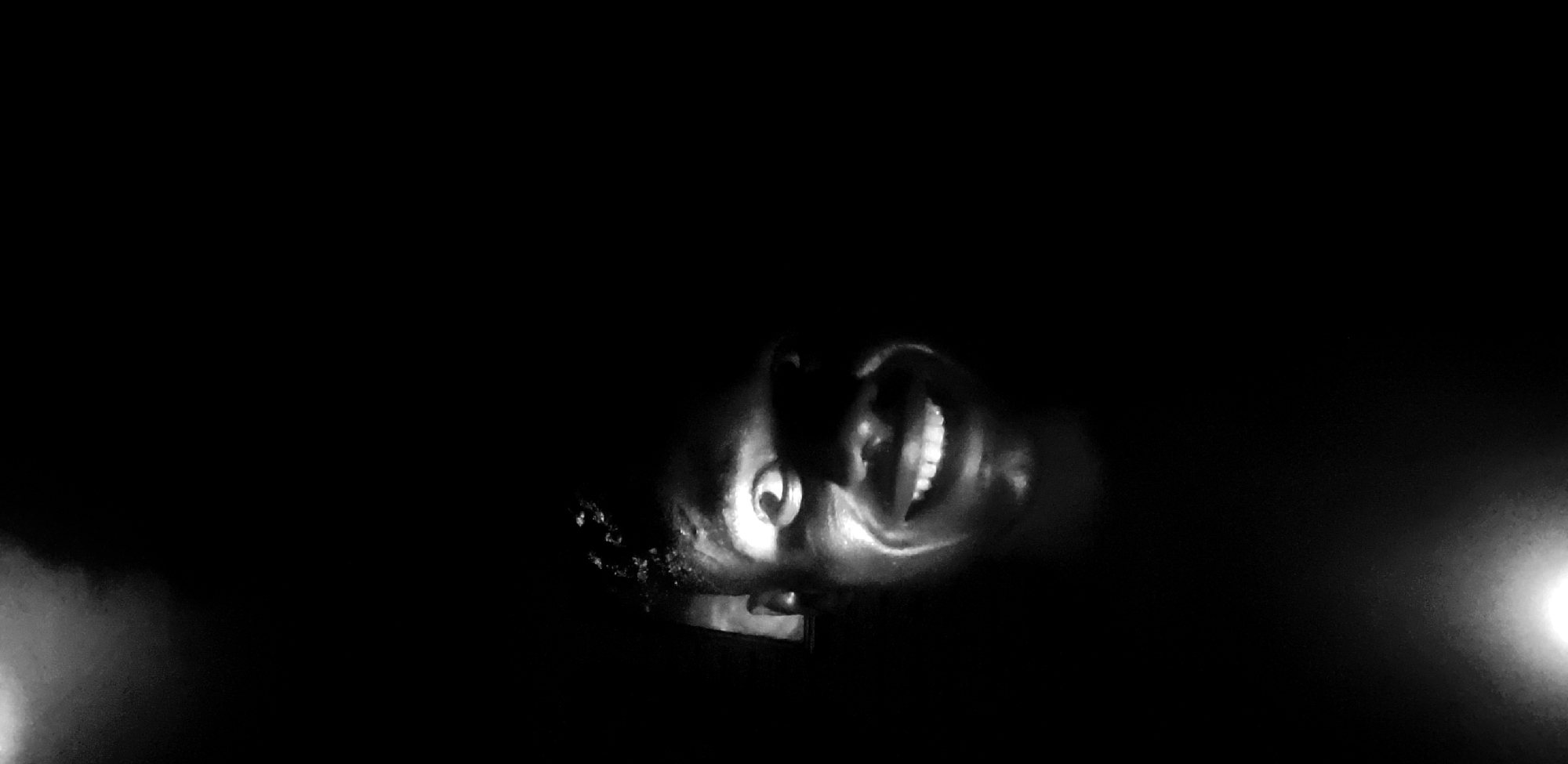 Person photographed smiling upward in nighttime Narayi, Nigeria