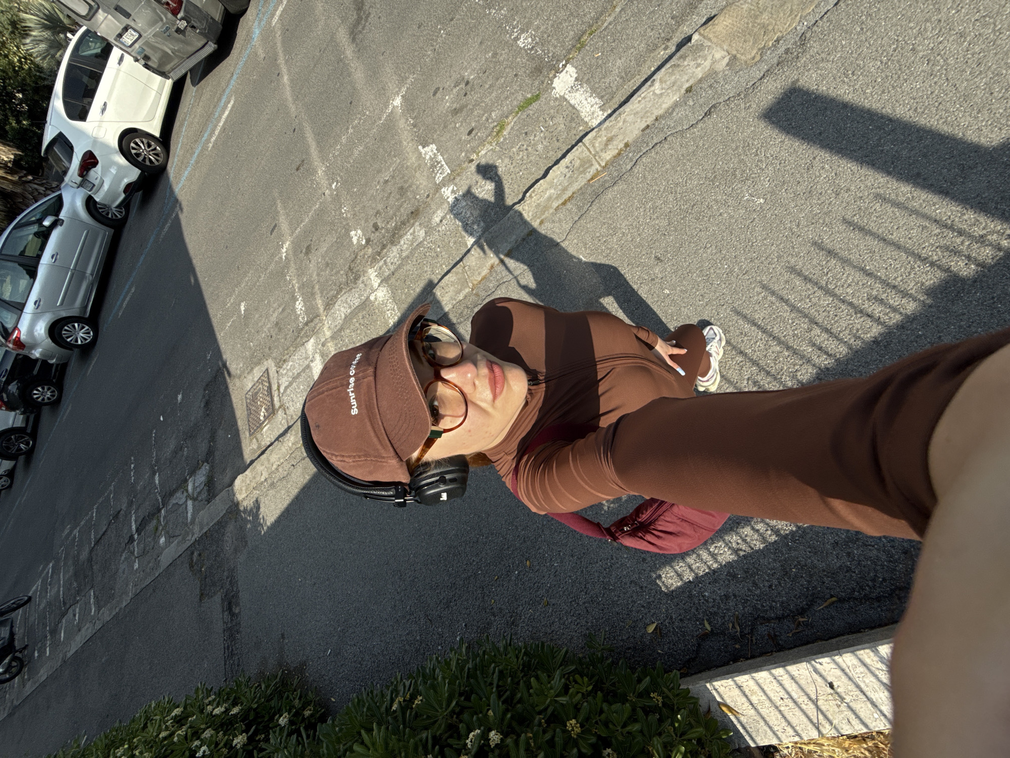 Woman takes selfies in brown tracksuit on Sanremo street
