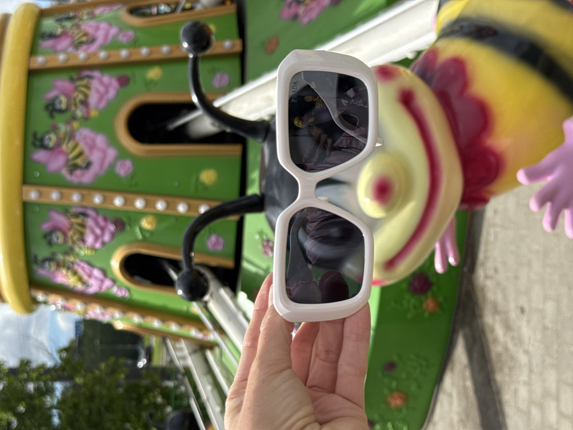 Woman poses with Prada sunglasses at Saint Petersburg amusement park