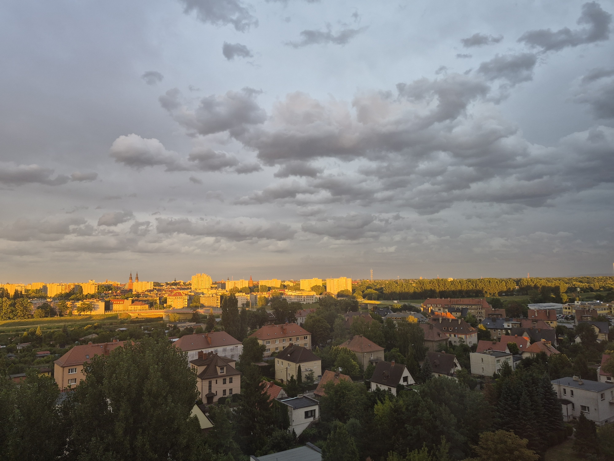 City skyline at golden hour with rainbow and forest foreground