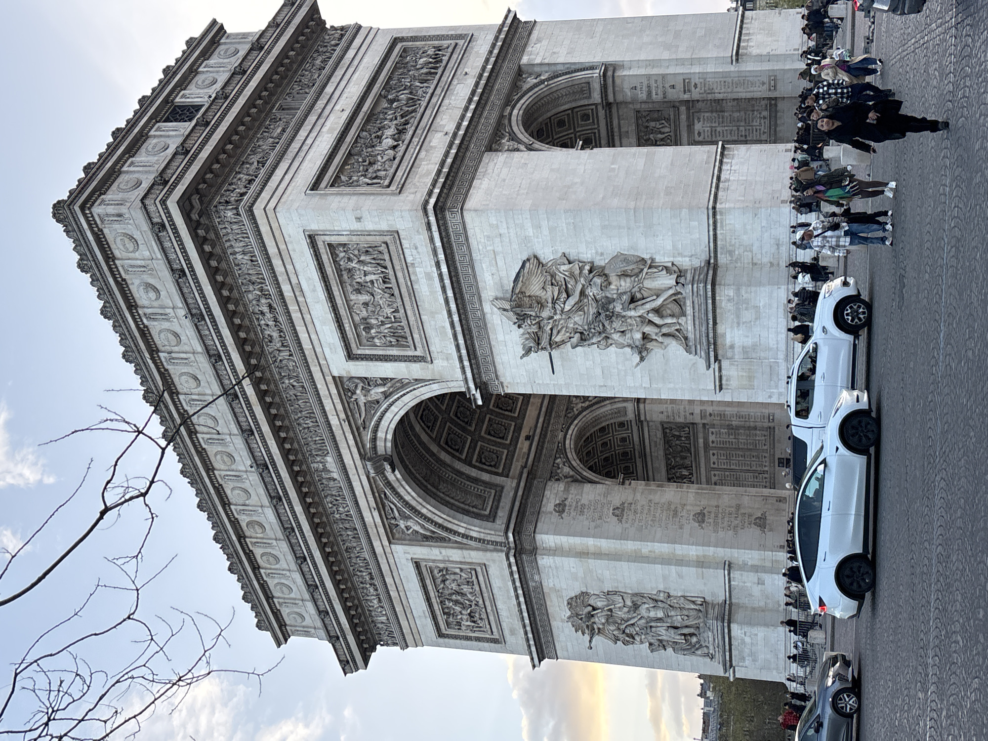 Tourist documents Arc de Triomphe from street level perspectives