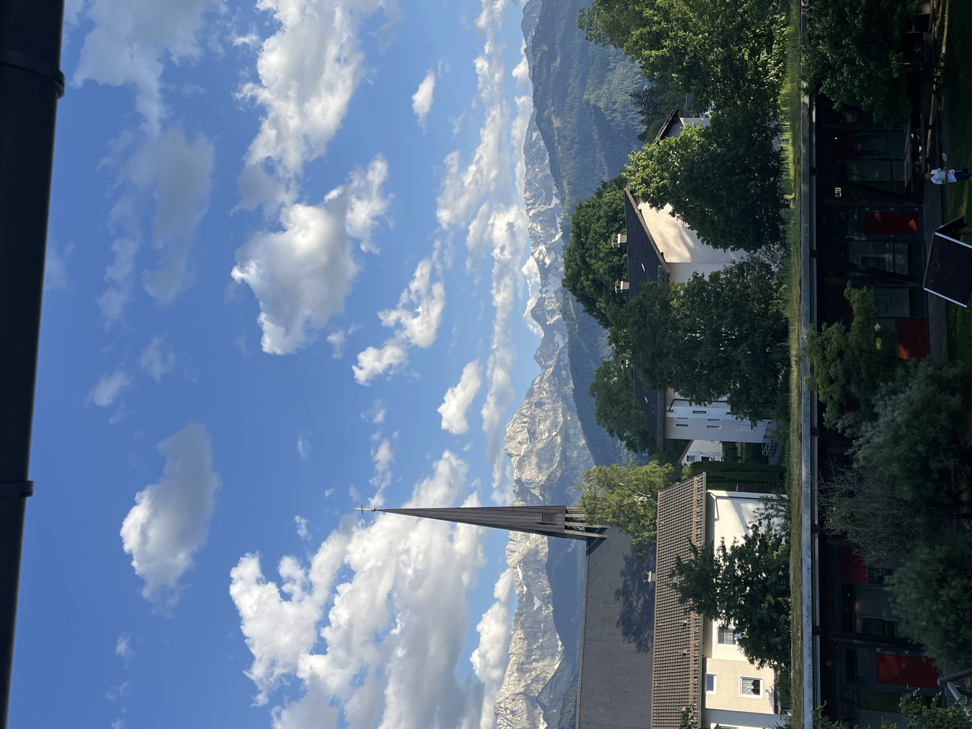 Church spire photographed against Bavarian Alps in Garmisch-Partenkirchen