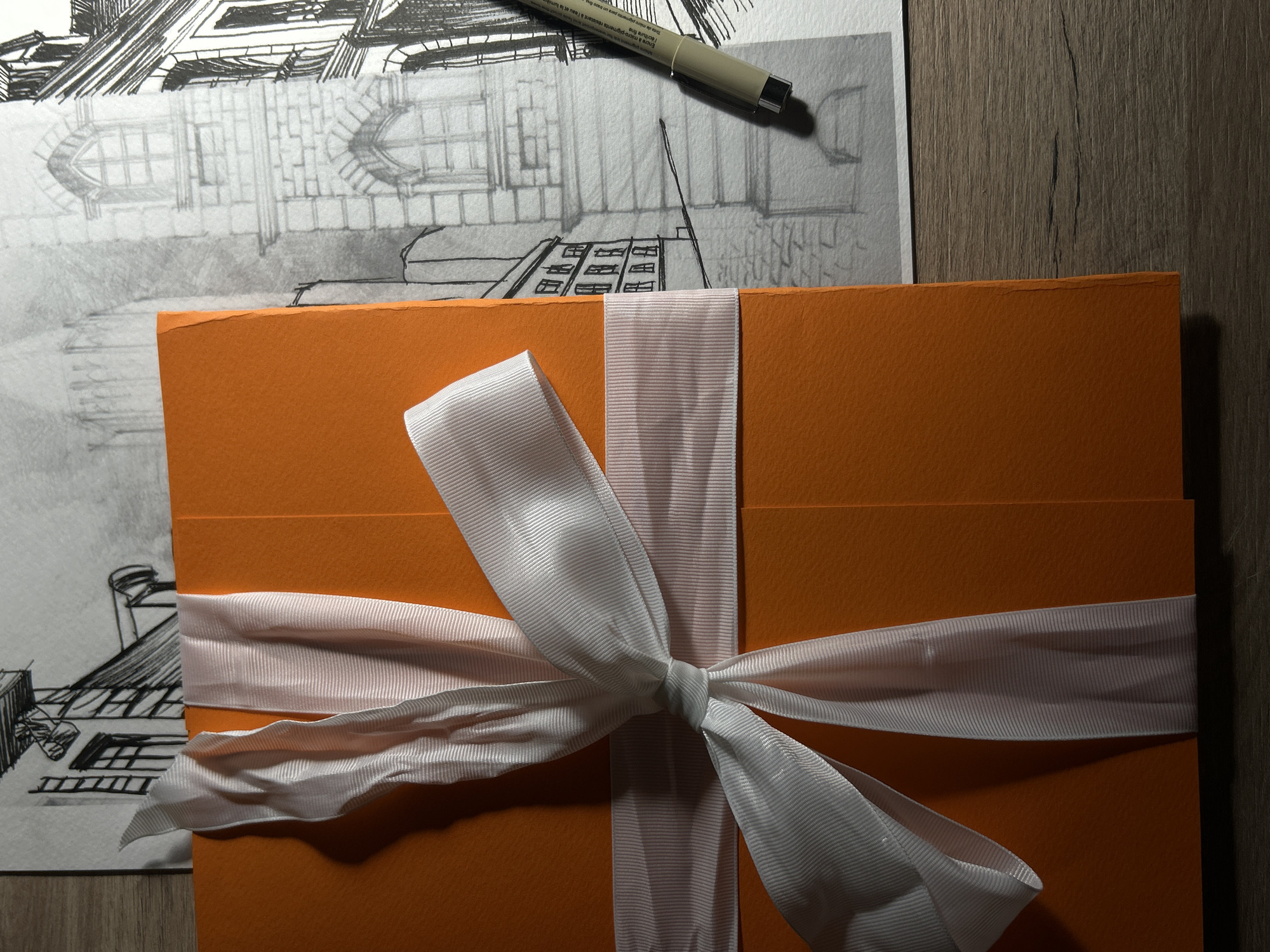Architectural workspace with orange ribbon-tied box documented in Sofia