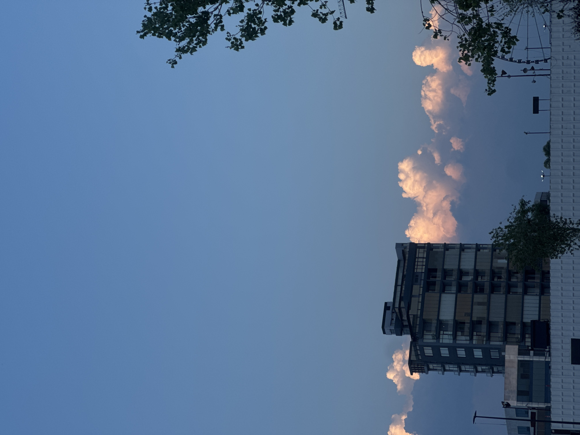 Pink clouds shroud buildings in evening Puebla cityscape