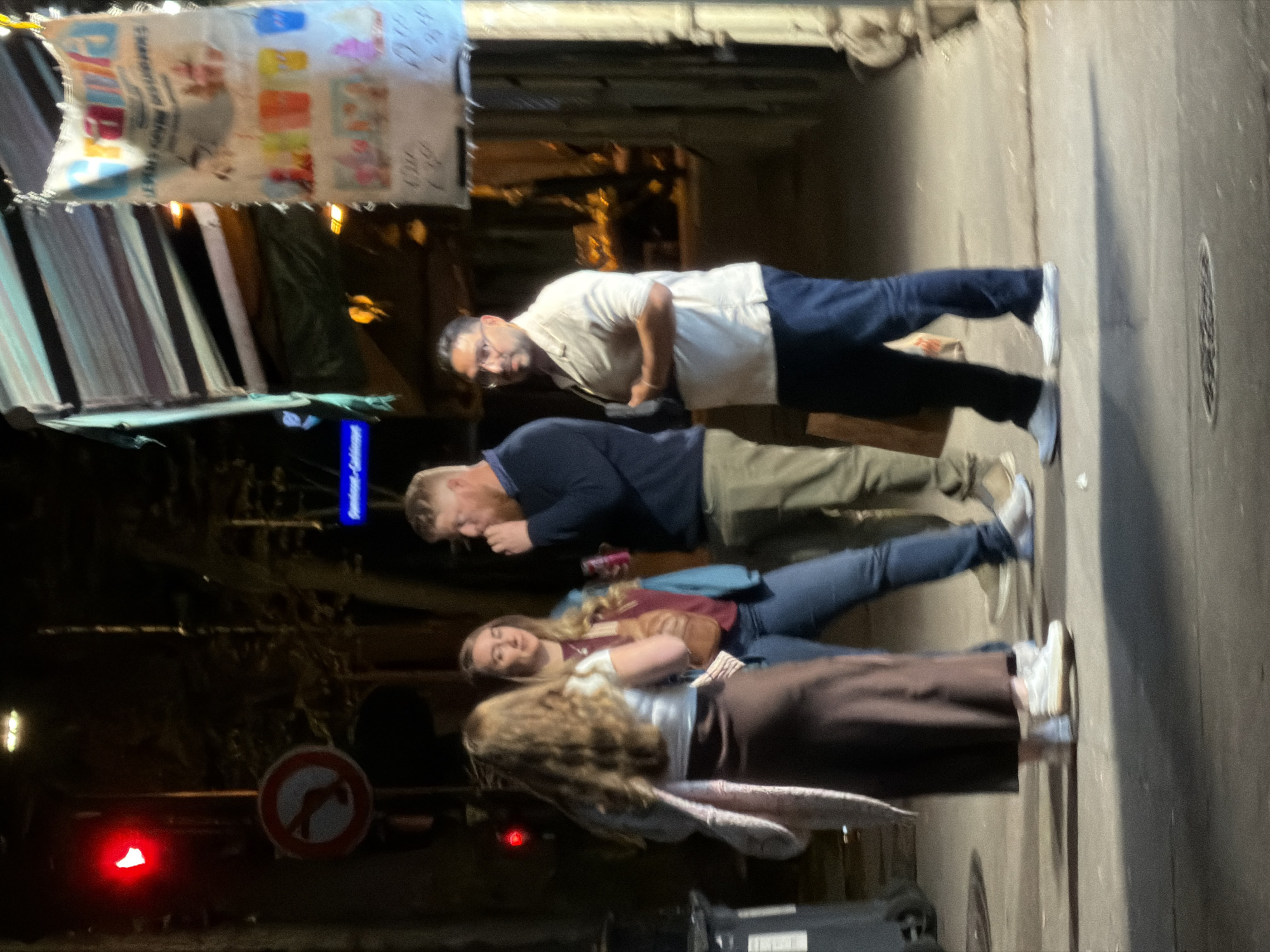 Evening gathering captured near illuminated Paris storefront