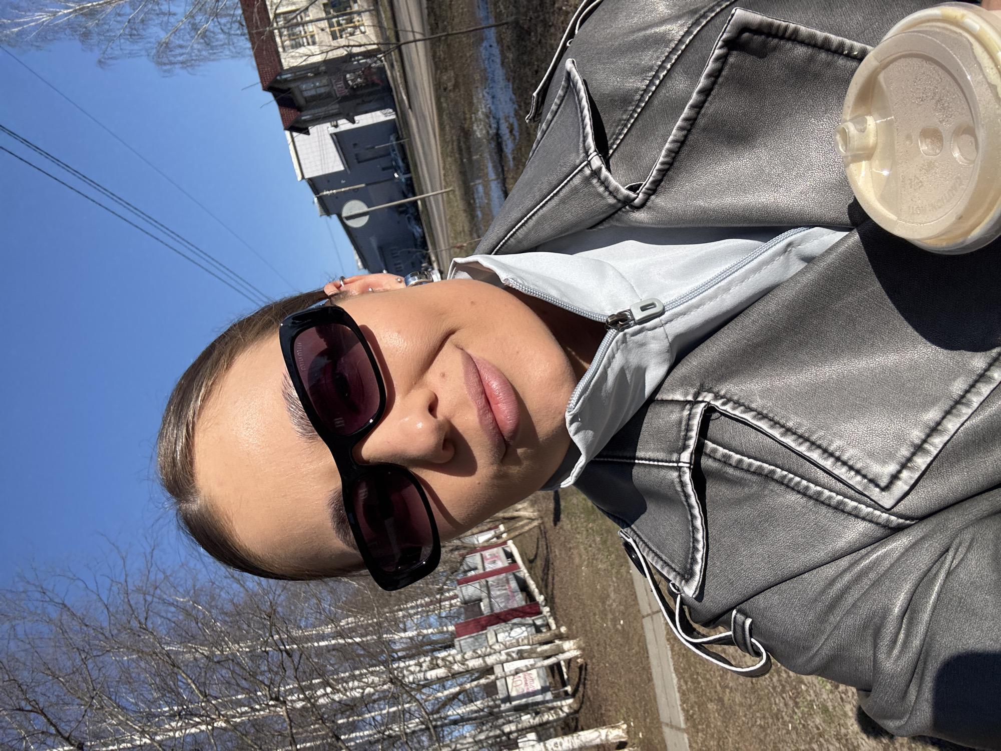 Woman with coffee cup spotted on sunny street in Chernushka