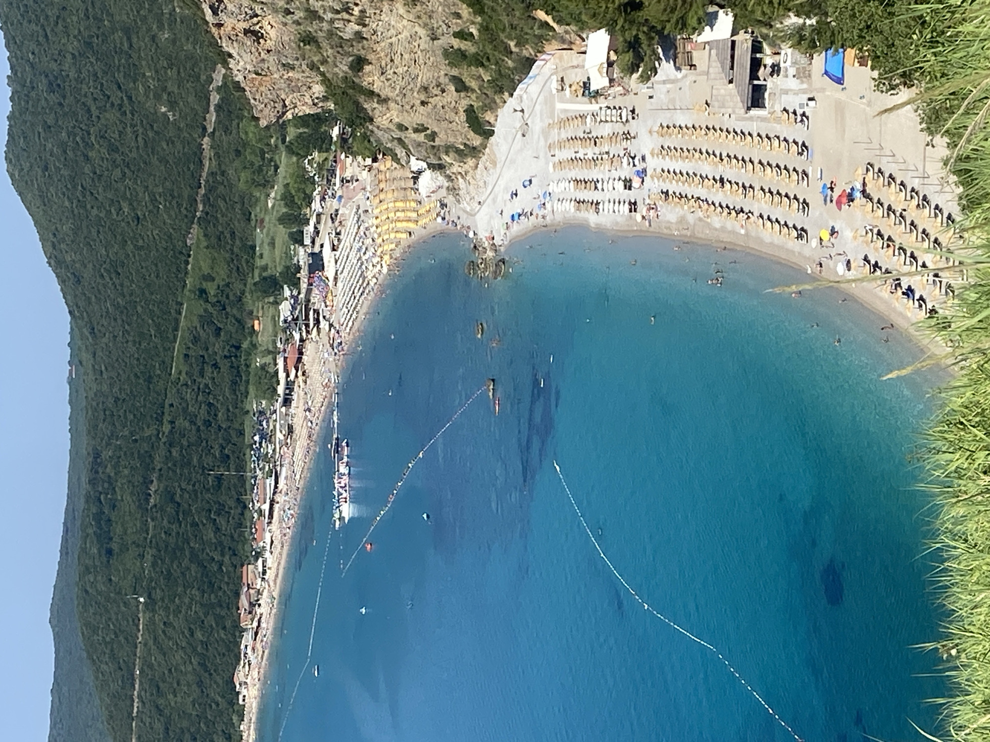 Crowded Montenegrin beach bay on a calm summer morning