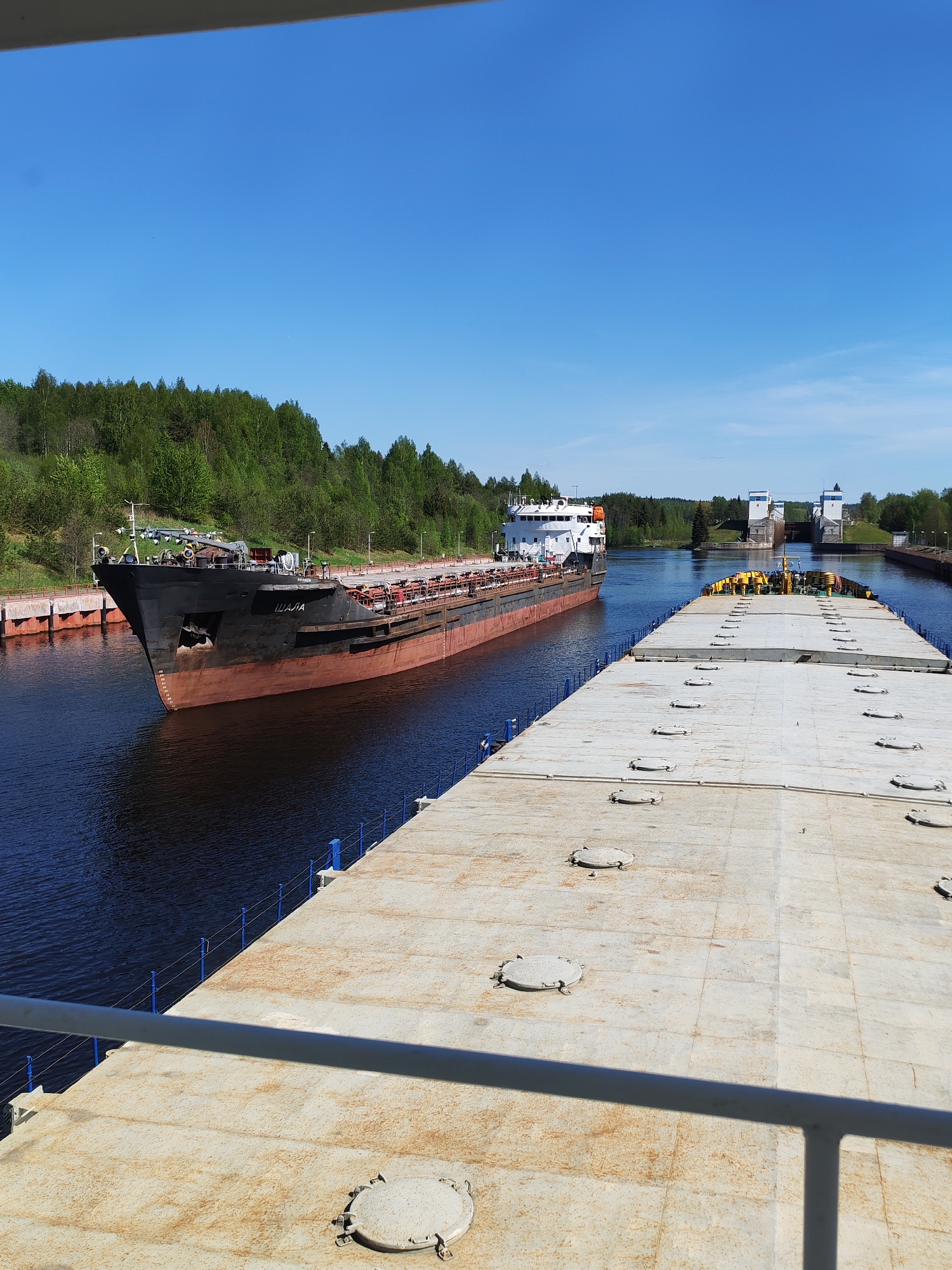 Barges navigate canal locks in Markovo, Russia