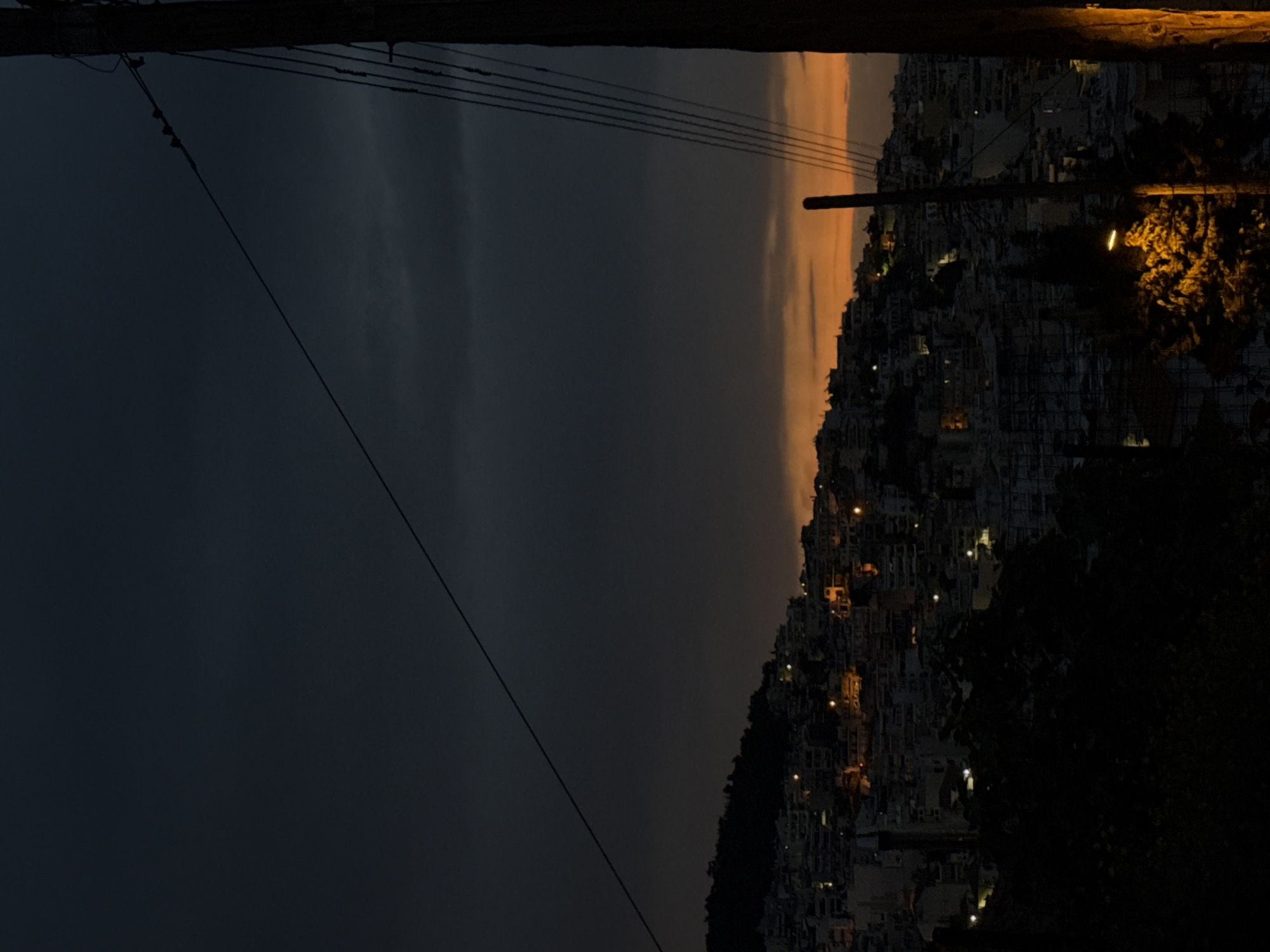 Dramatic sunset captured over hillside city of Kavala, Greece