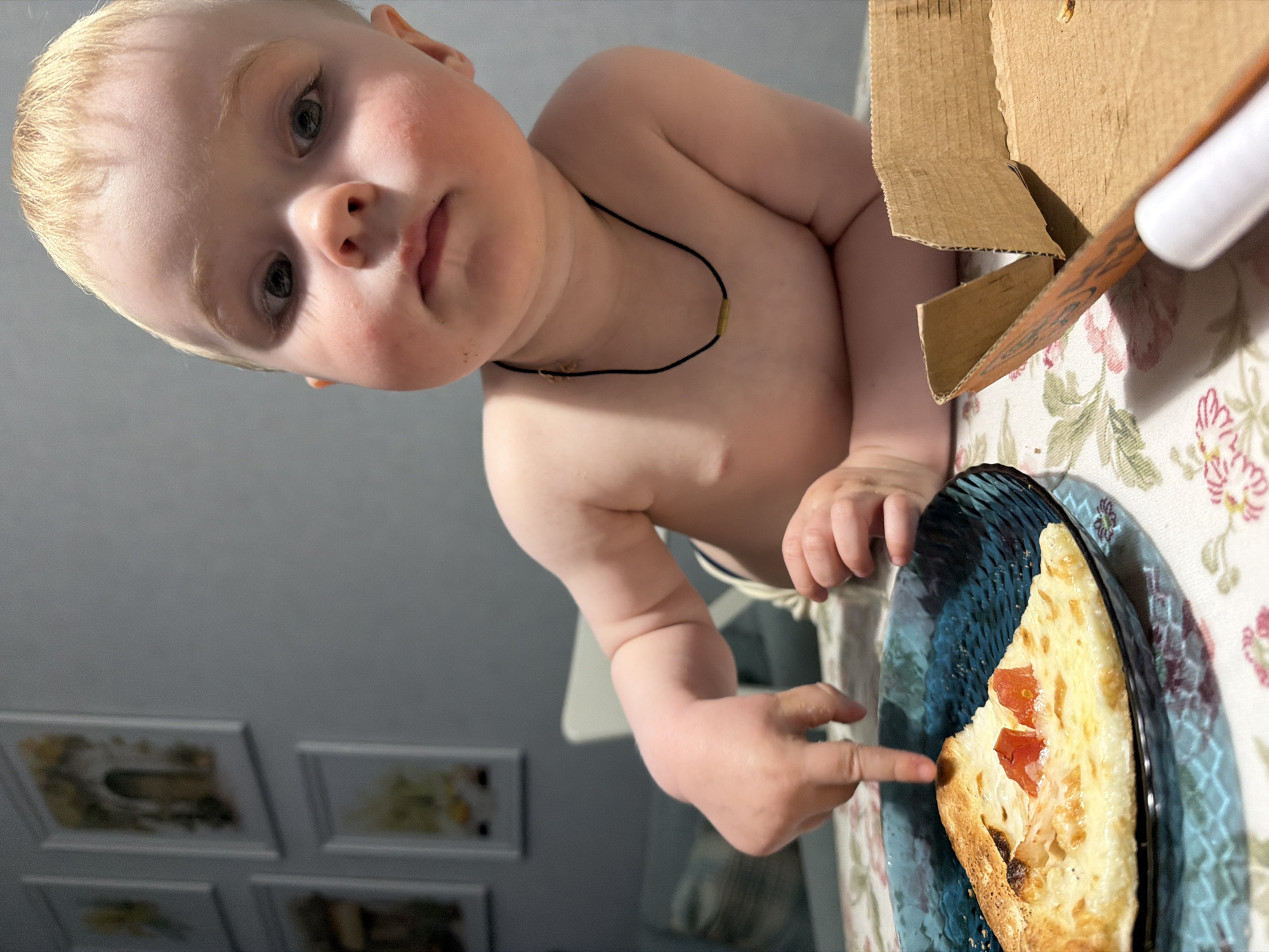 Child enjoys pizza dinner with dog in Votkinsk home