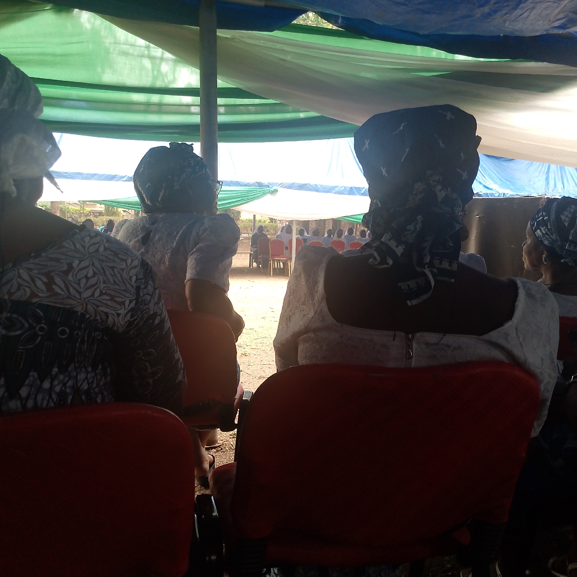 Women gather under canopy for outdoor community event