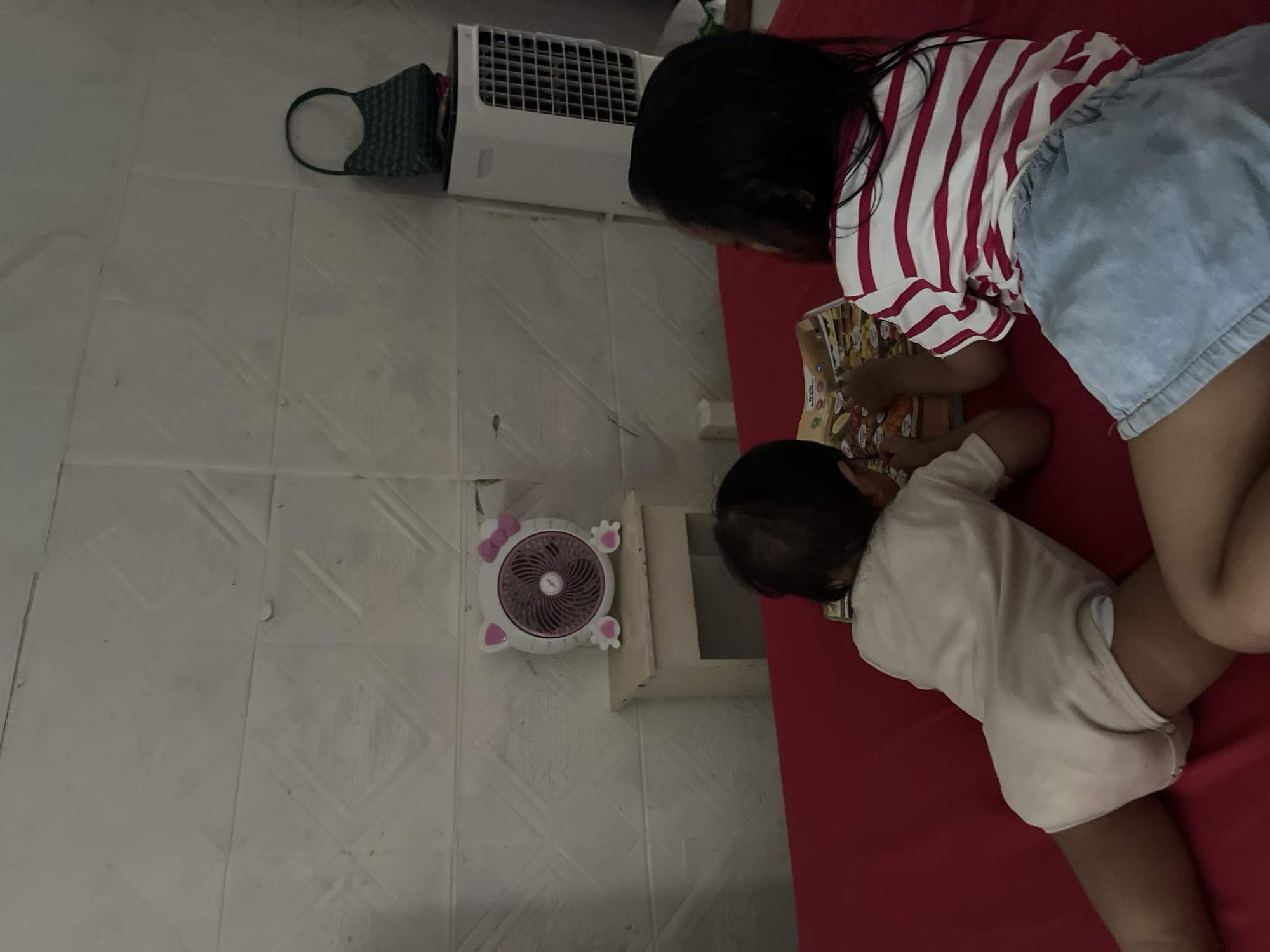 Kids reading and playing games on a red bed, selfies nearby