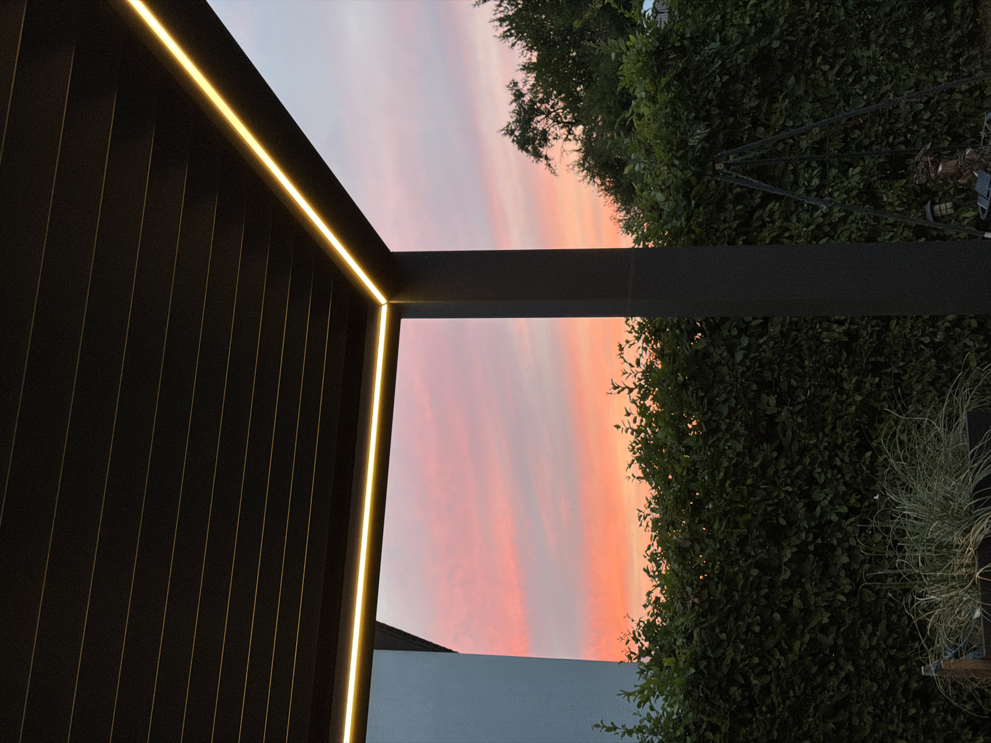 Backyard dinner under a pergola as dusk settles in Junglinster