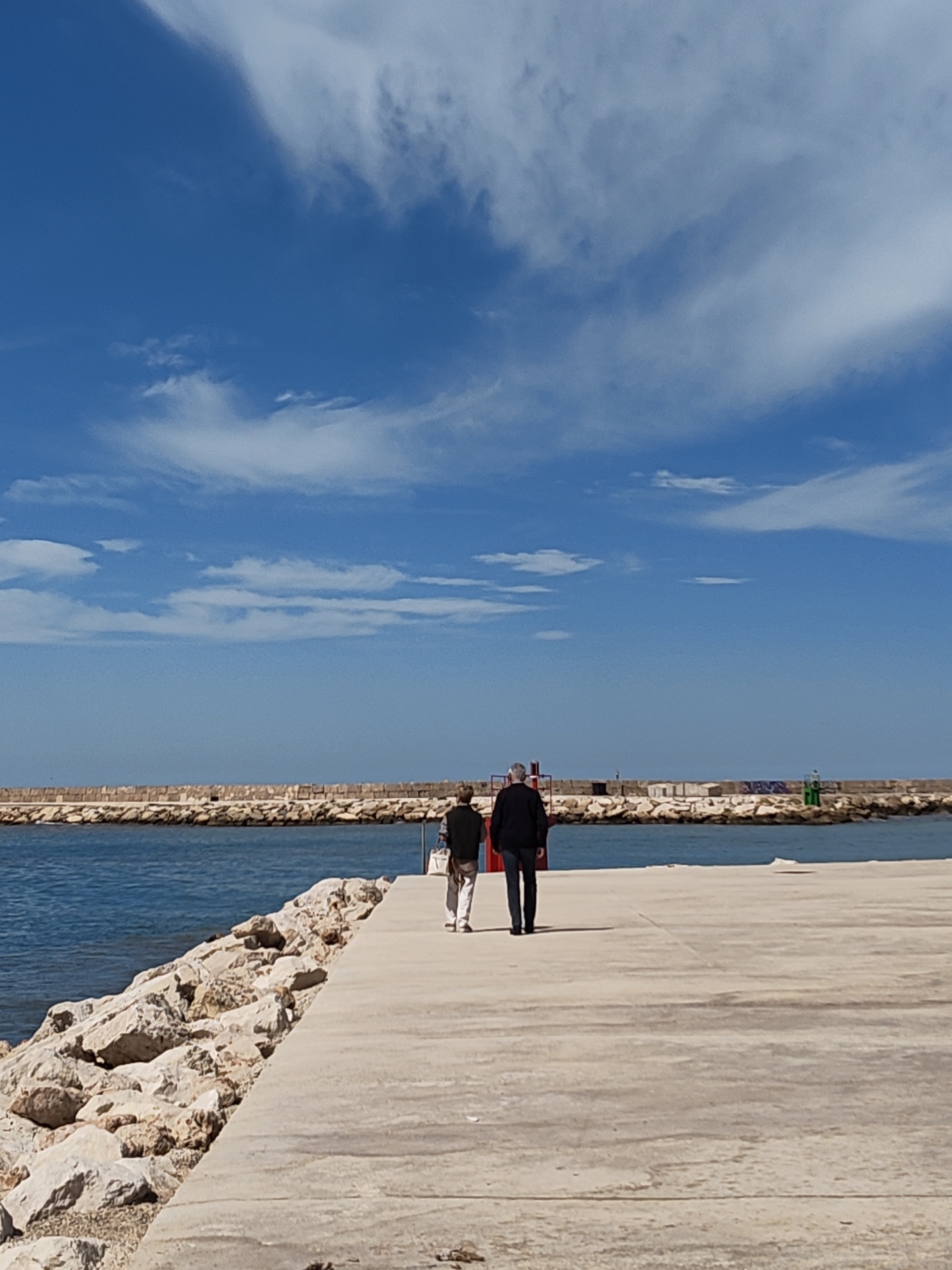 Afternoon stroll and harbor activity at Dénia lighthouse pier