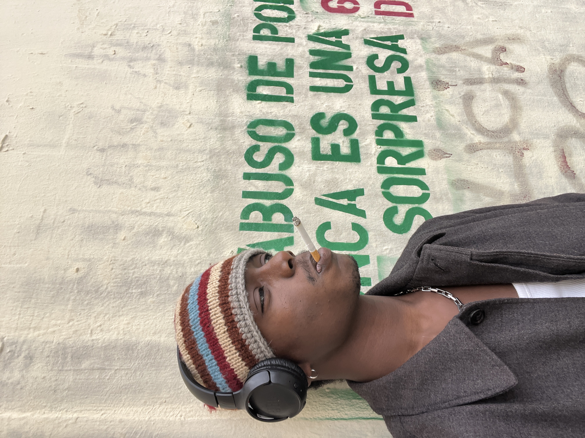 Young man rests against wall in Barcelona