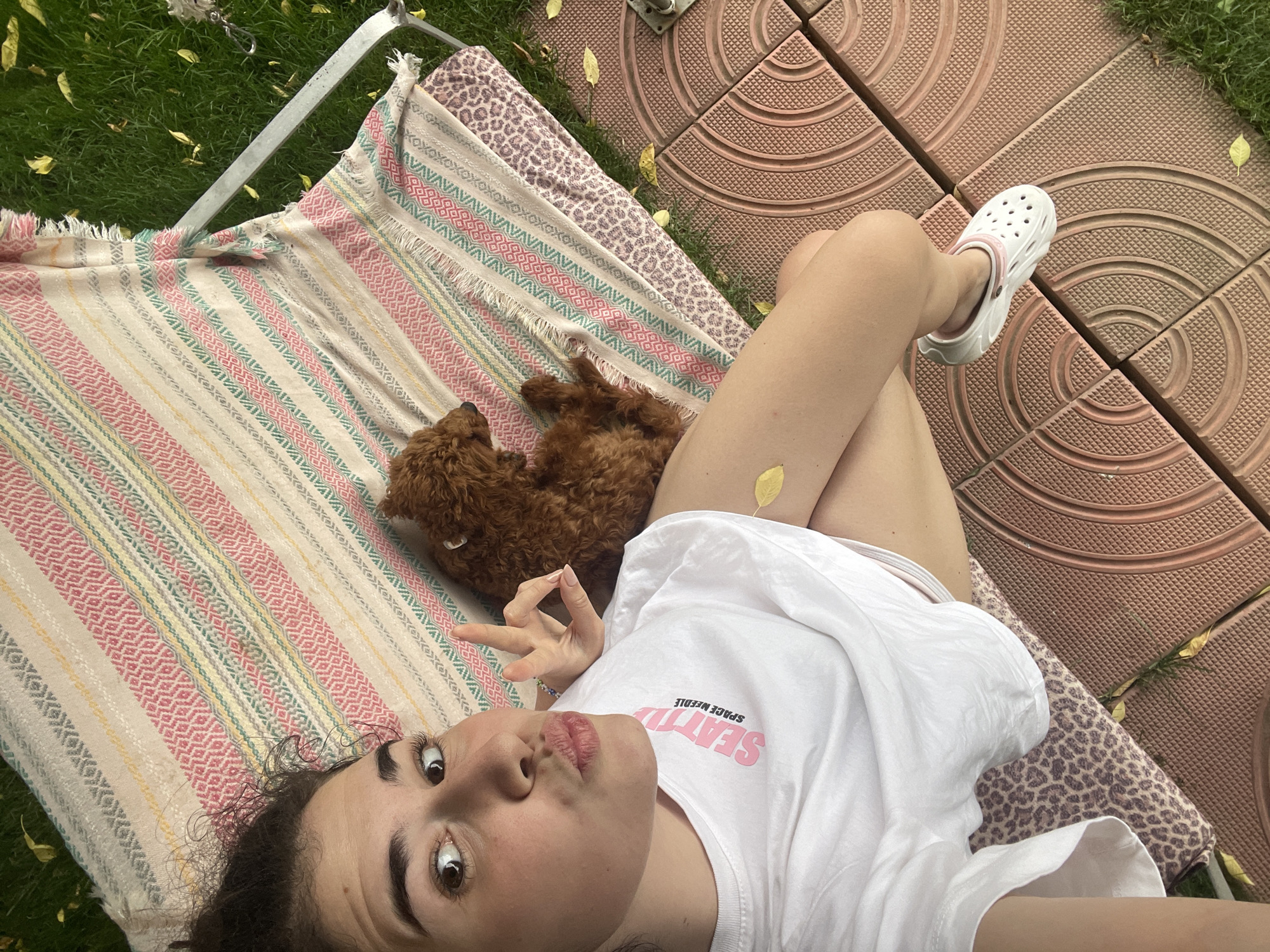 Woman and poodle enjoy rainy afternoon in Sofia backyard