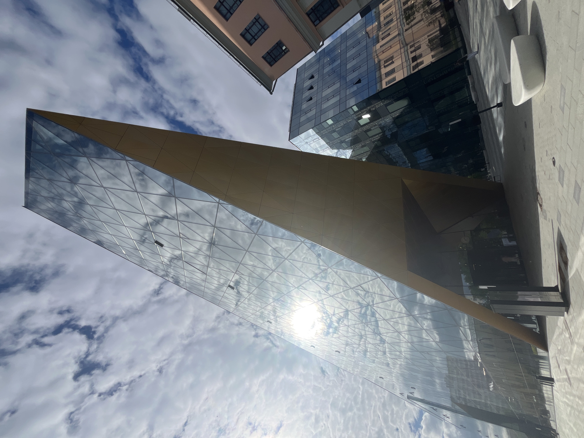 Modern glass complex with math-etched facades near a tram intersection
