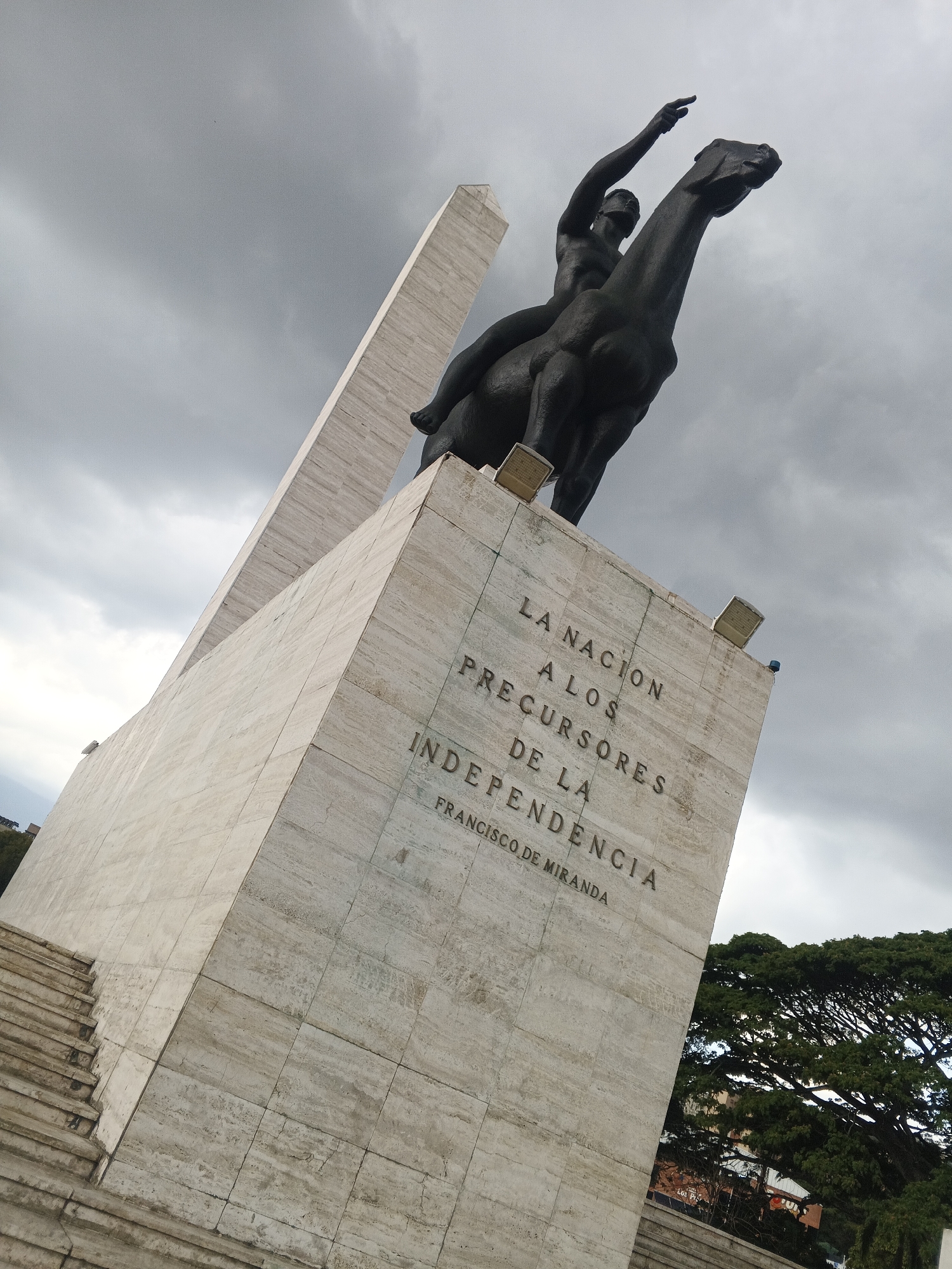 Park visitors document fountains and equestrian monument during evening hours