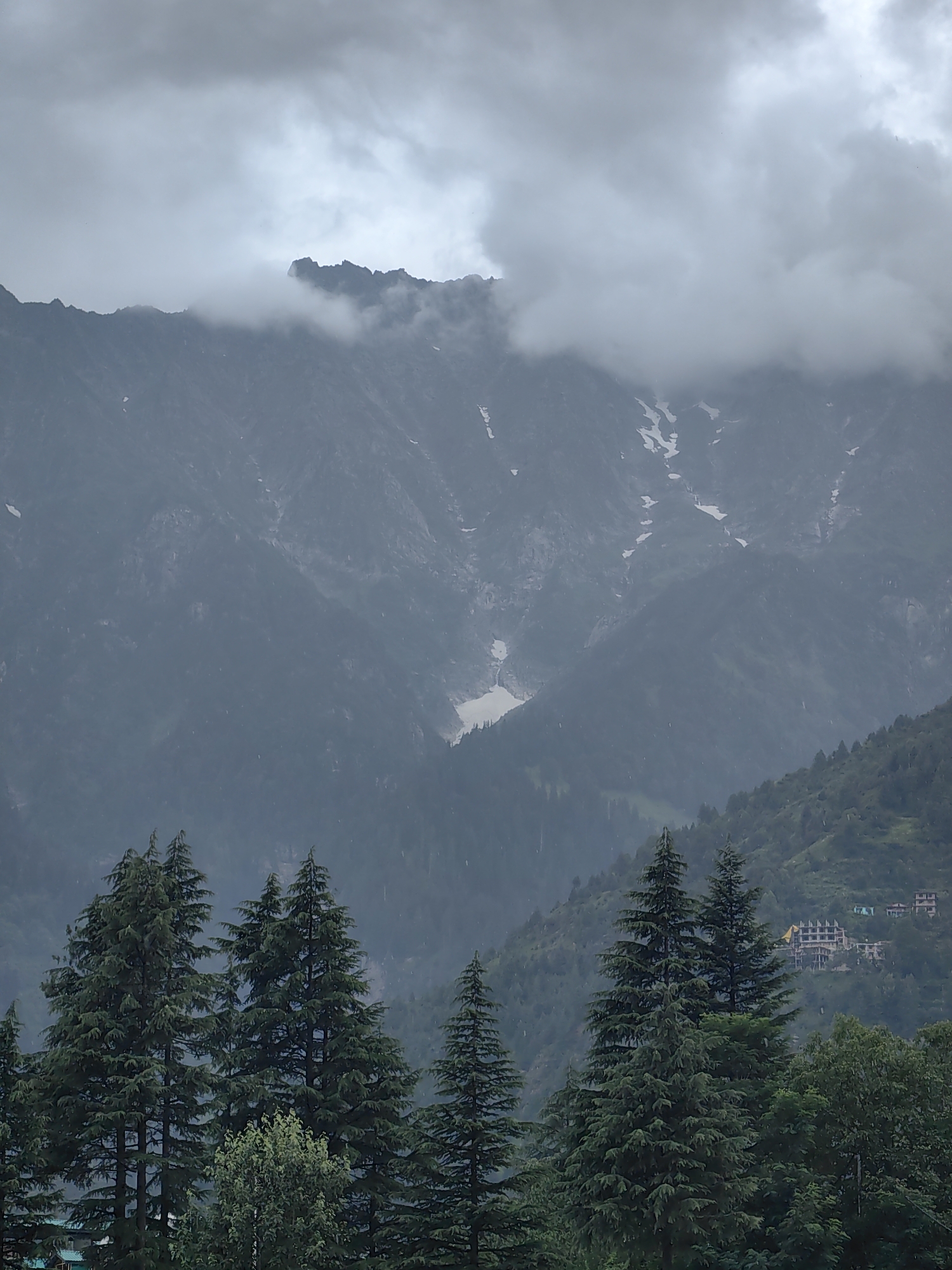 Misty Himachal valley: mountain infrastructure and cloud-covered peaks